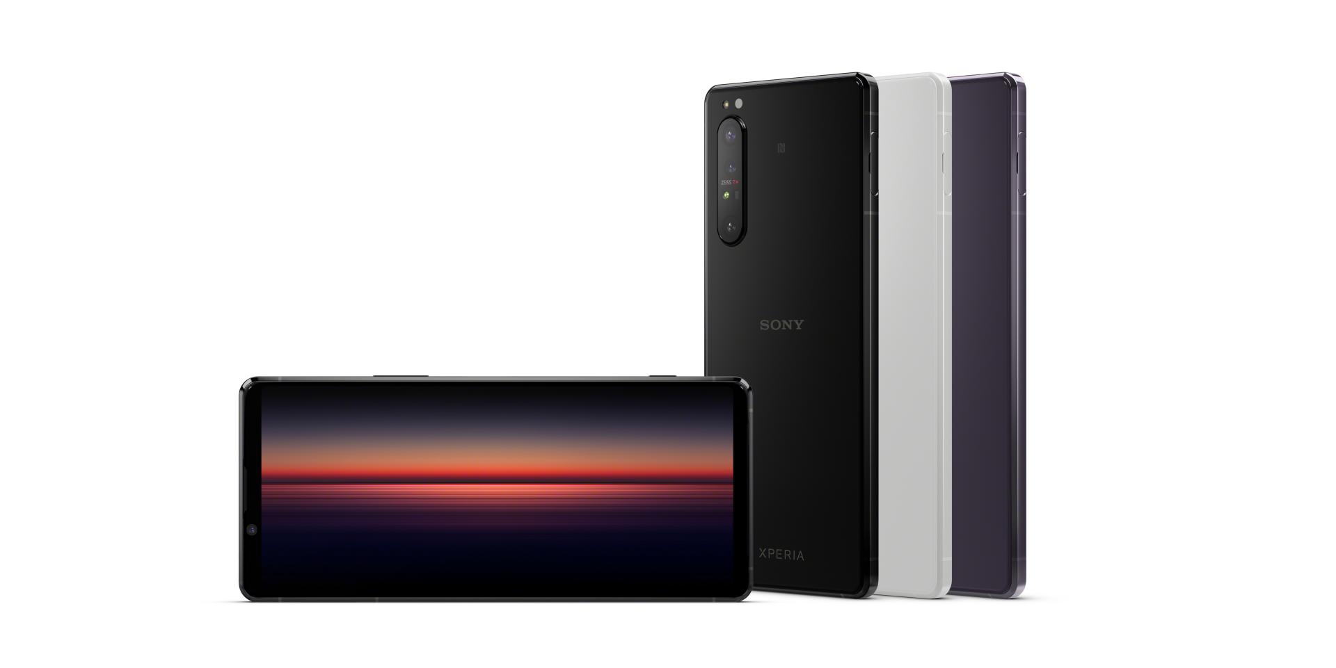 Three Sony smartphones, each in a different color, are displayed standing upright with one phone showing a colorful sunset-themed screen in front, featuring ZEISS optics.