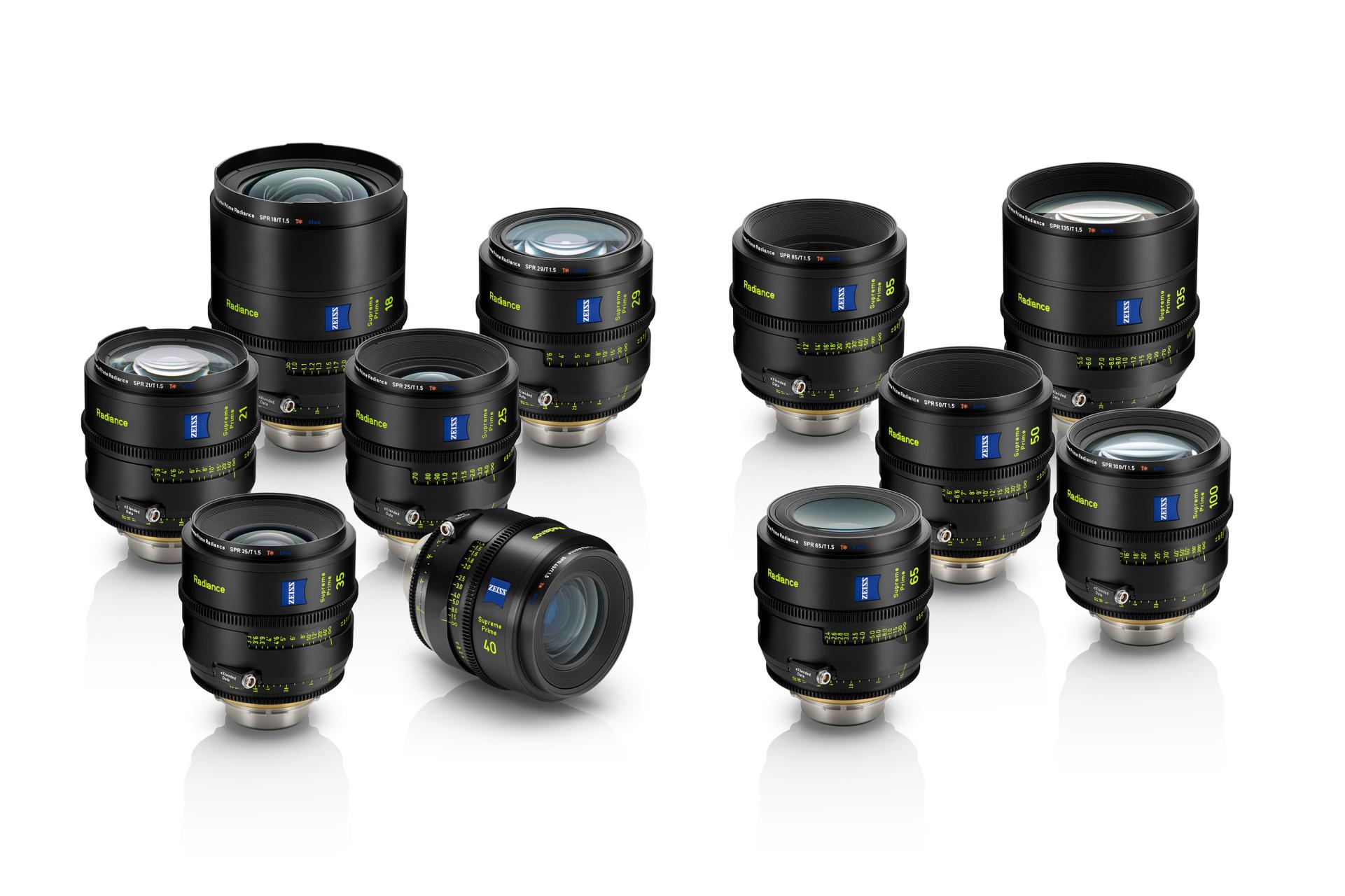 A collection of professional ZEISS camera lenses arranged on a white reflective surface.