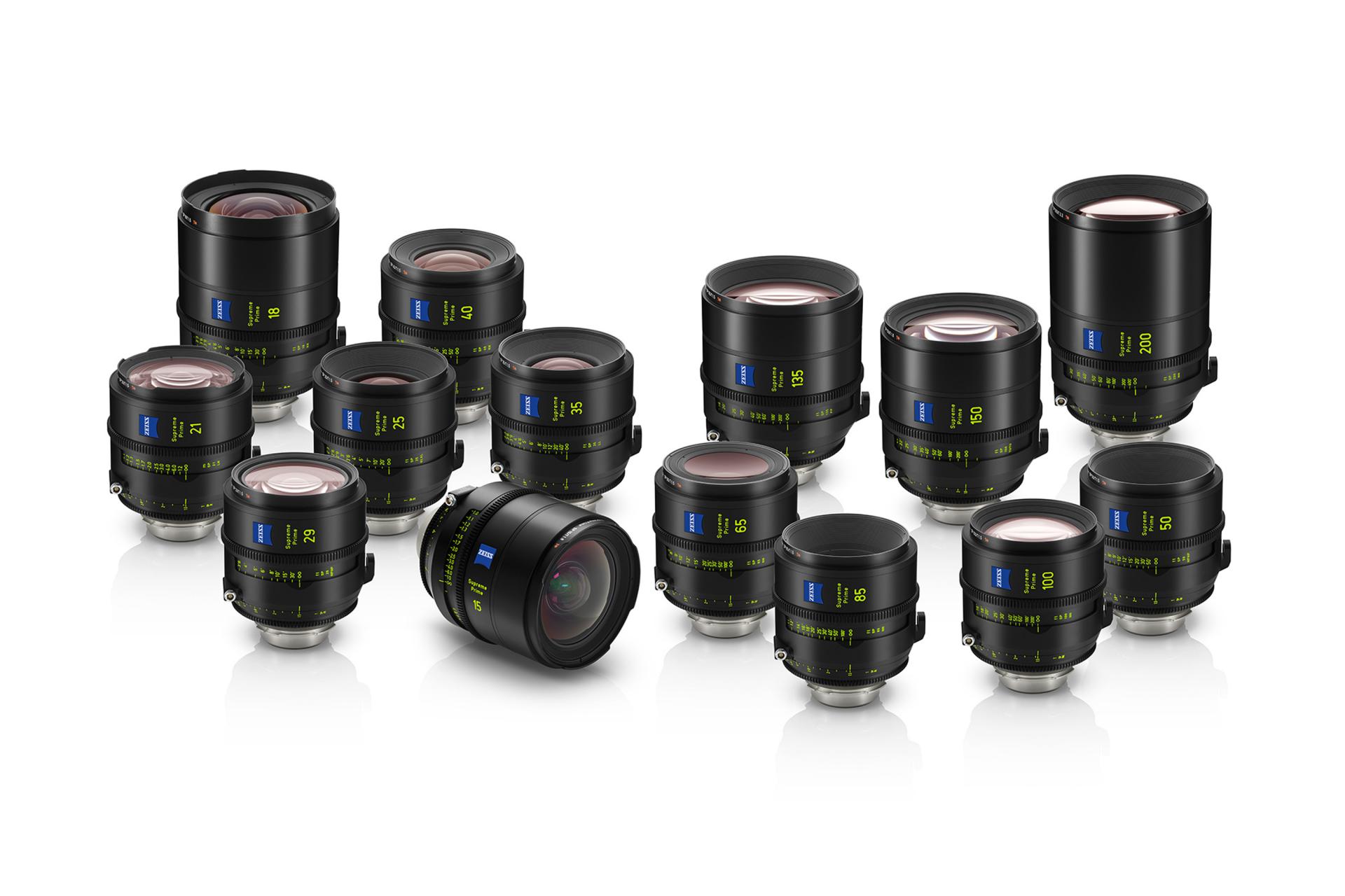 A collection of fourteen professional ZEISS camera lenses arranged on a white surface.