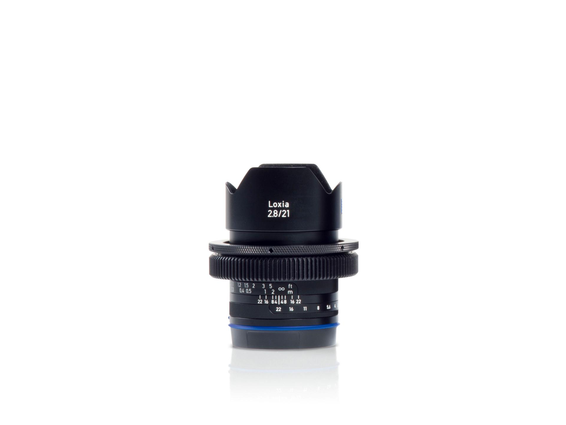 Front view of a ZEISS Loxia 2.8/21 camera lens with visible focus and aperture markings.