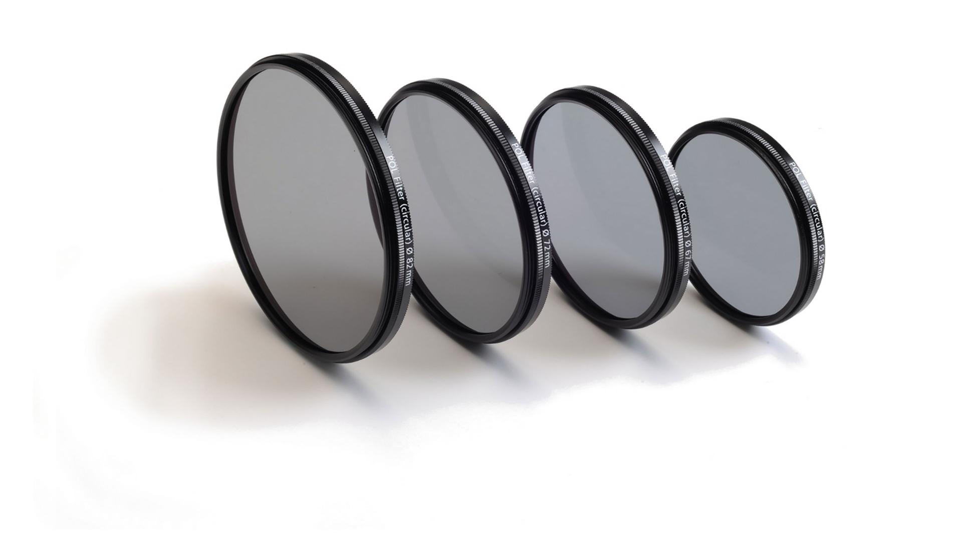 Four ZEISS camera lens filters of varying sizes are arranged in a row on a white background.