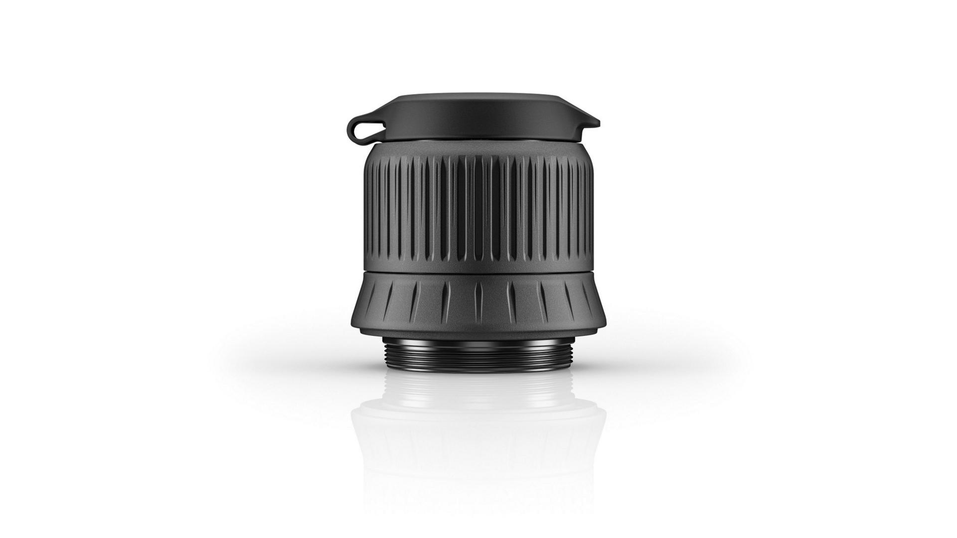 Black ZEISS lens accessory with ribbed texture and protective cap, displayed on a white reflective surface.