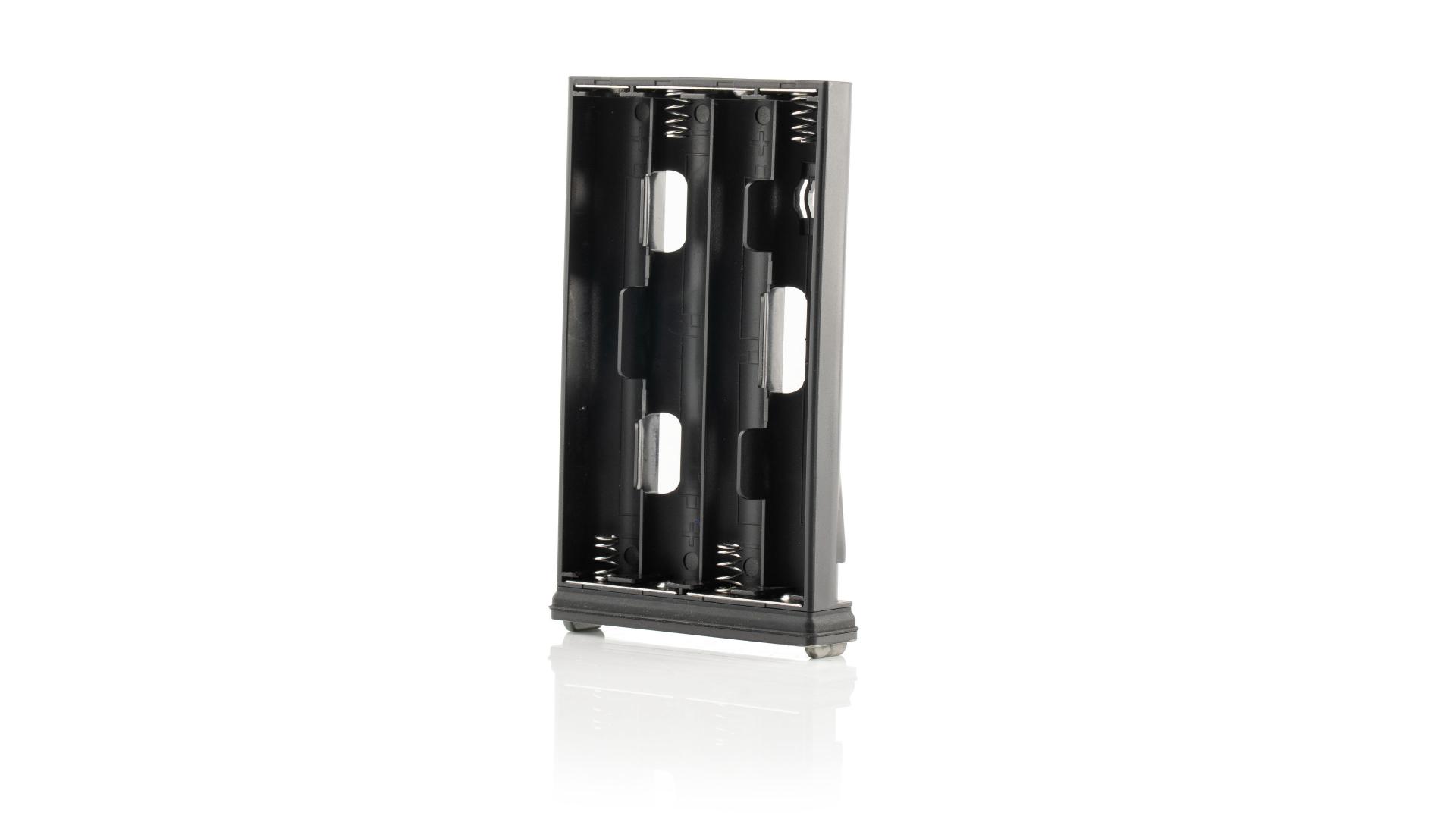 Black ZEISS battery holder designed to accommodate four AA batteries, shown standing upright on a white reflective surface.