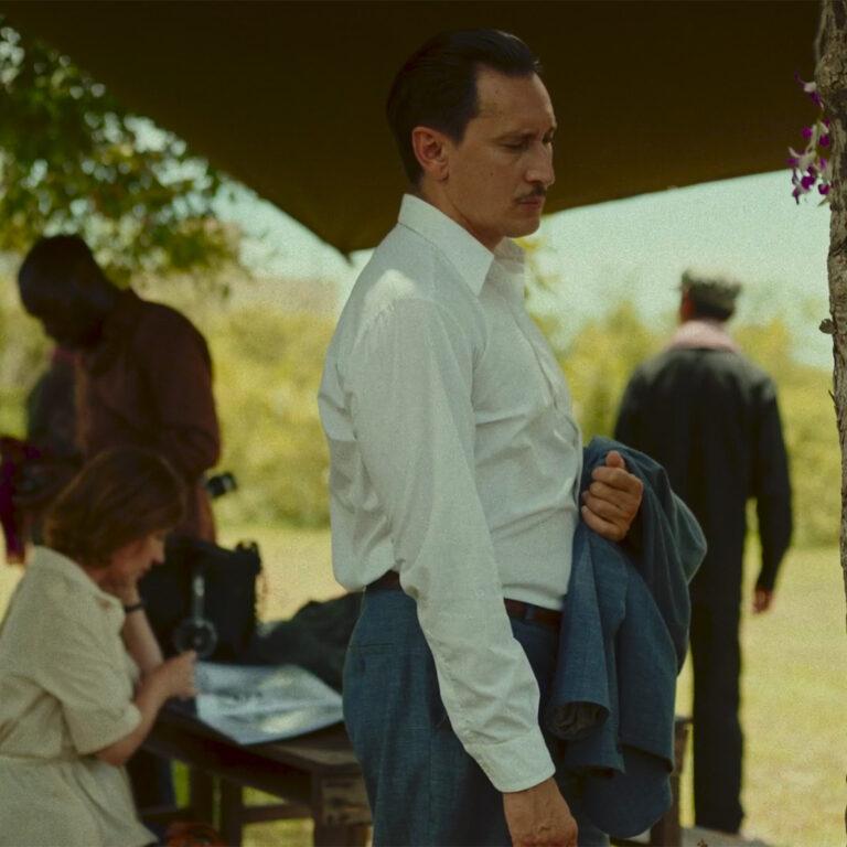 Two people are working with professional film production equipment, including a camera and monitor, in a studio setting featuring ZEISS lenses.