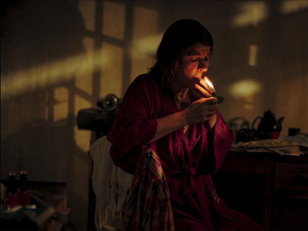 A group of people stands outdoors while a teenage boy reads from a paper as reporters hold microphones toward him.