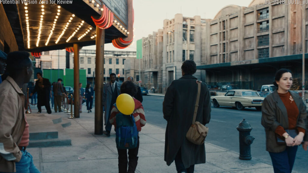 A group of people stands outdoors while a teenage boy reads from a paper as reporters hold microphones toward him.