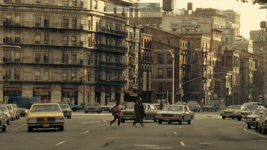 Two people are working with professional film production equipment, including a camera and monitor, in a studio setting featuring ZEISS lenses.
