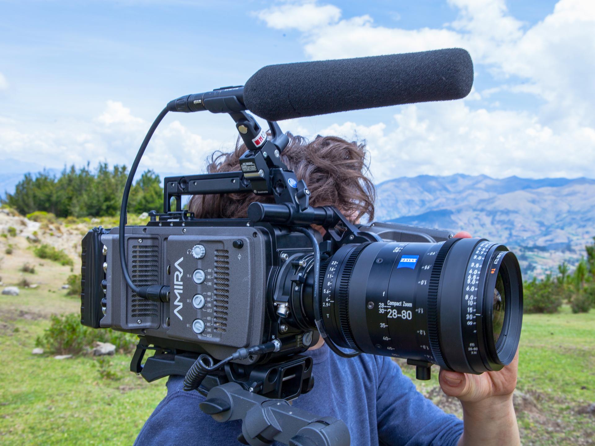 A person is filming outdoors with a professional ARRI AMIRA camera equipped with a ZEISS Compact Zoom 28-80mm lens.
