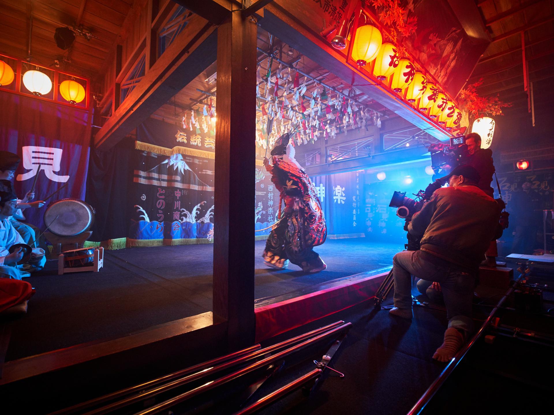A film crew captures a traditional Japanese stage performance in a vibrant, lantern-lit setting using ZEISS camera lenses.