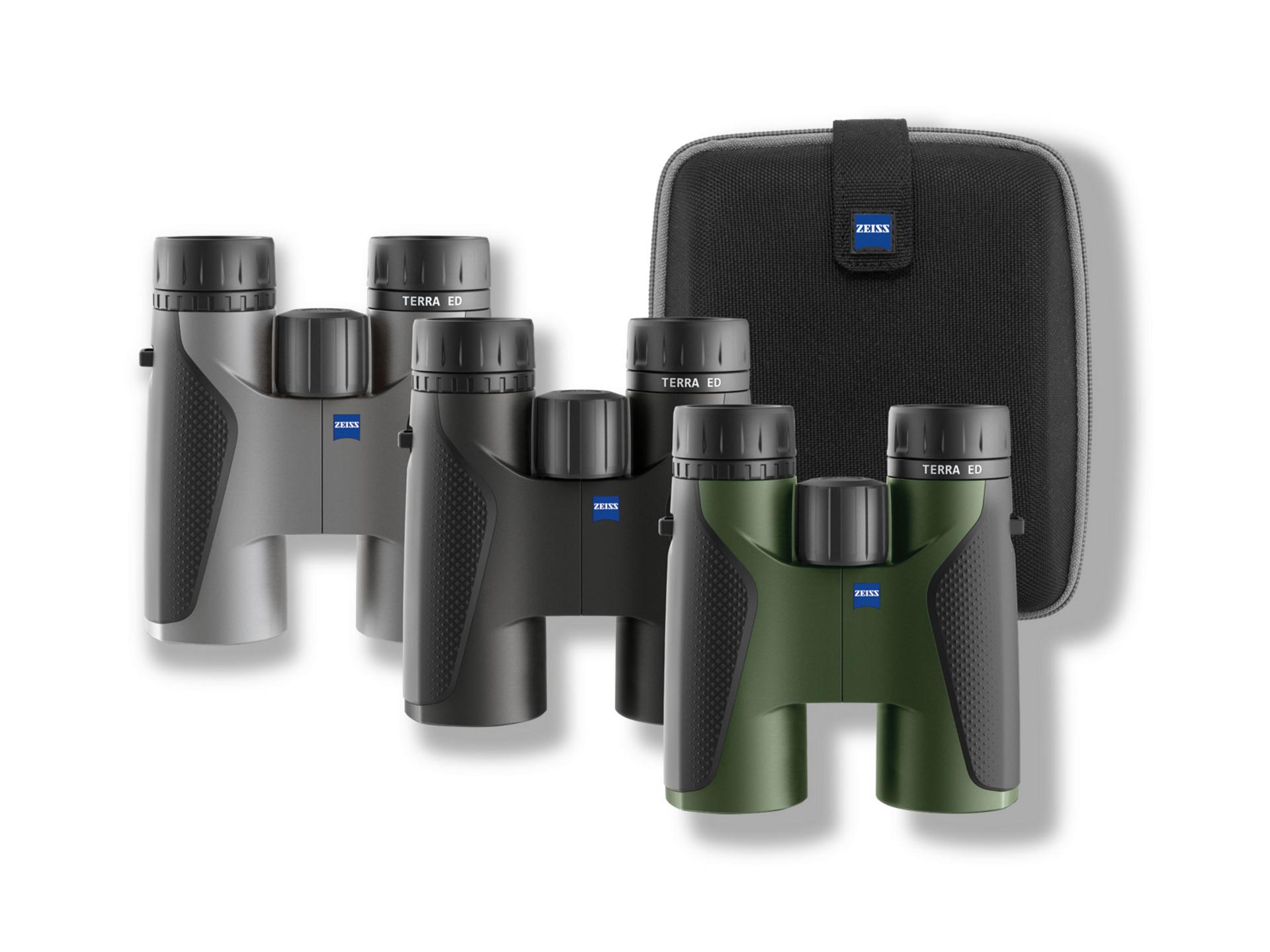 Three pairs of ZEISS TERRA ED binoculars in gray, black, and green are displayed alongside a black ZEISS carrying case.