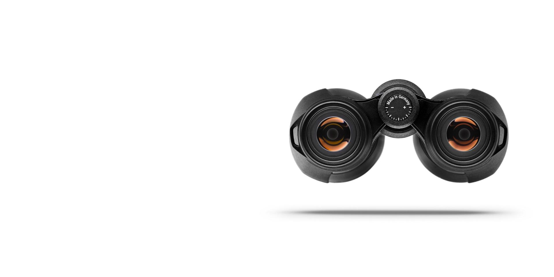 Front view of black ZEISS binoculars with orange lens reflections, centered on a white background with a soft shadow underneath.