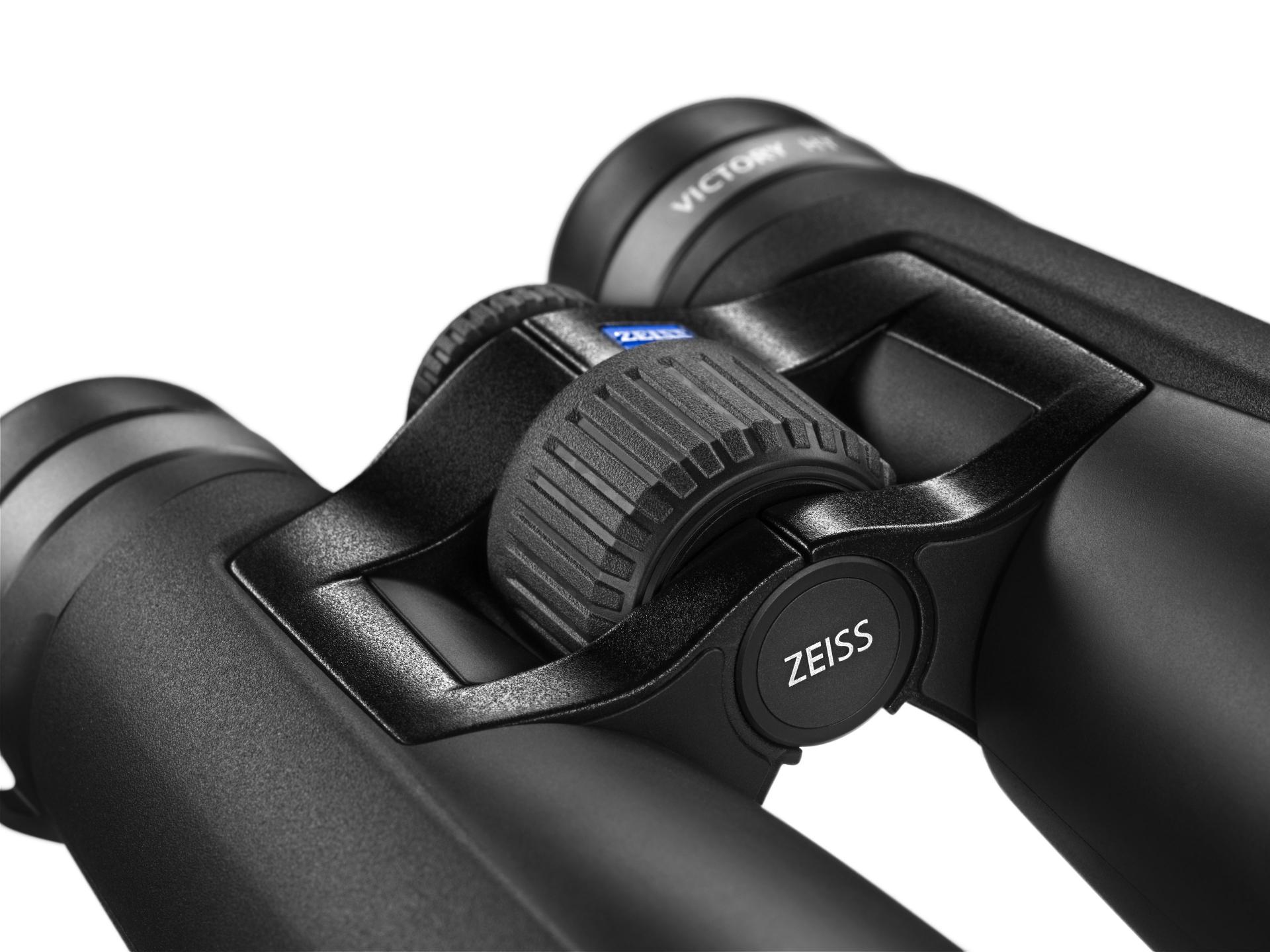 Close-up view of a pair of black ZEISS binoculars showing the central focus wheel and ZEISS branding.