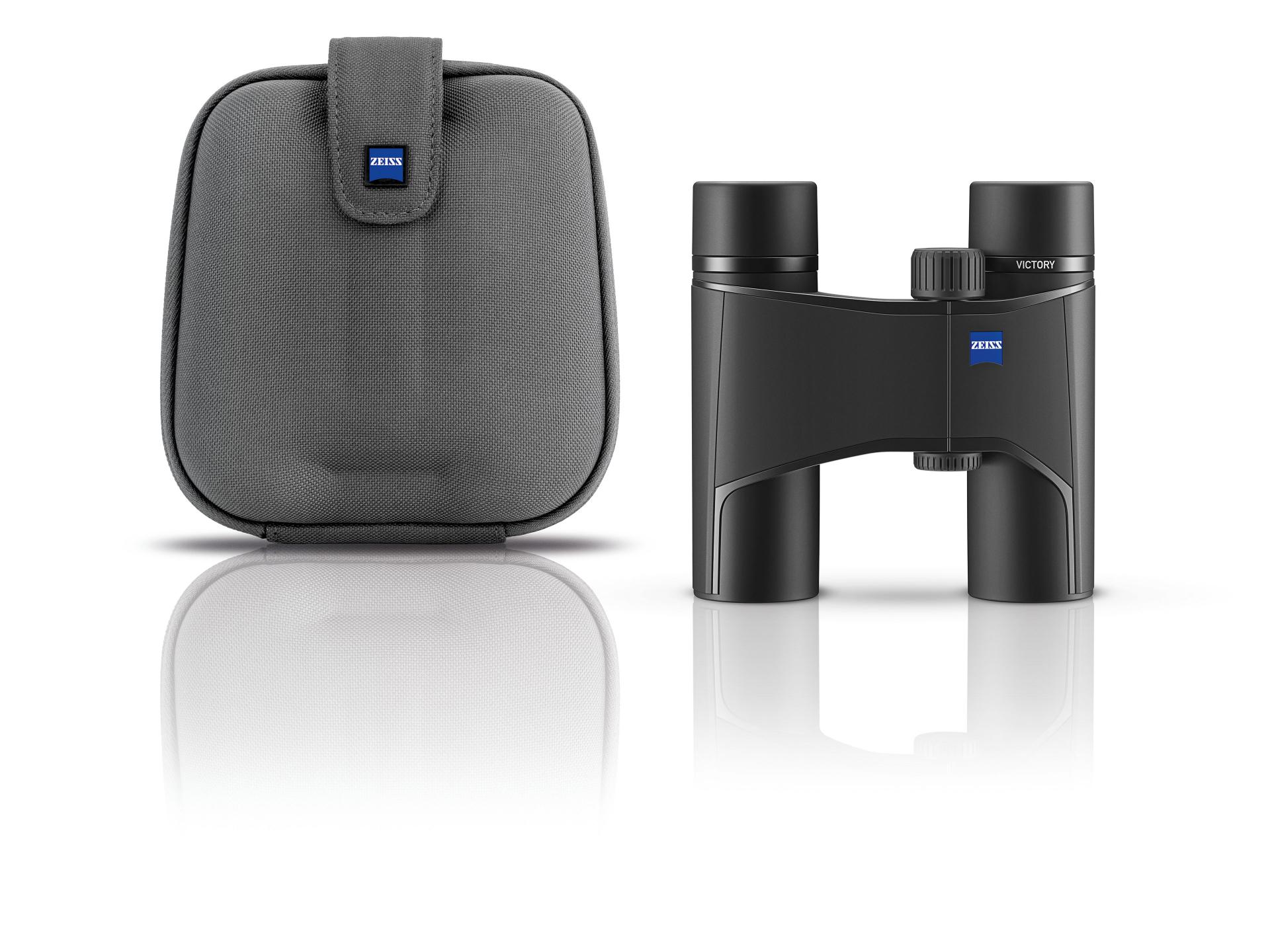 Compact black ZEISS binoculars are displayed upright next to a matching gray carrying case with the ZEISS logo on both items.