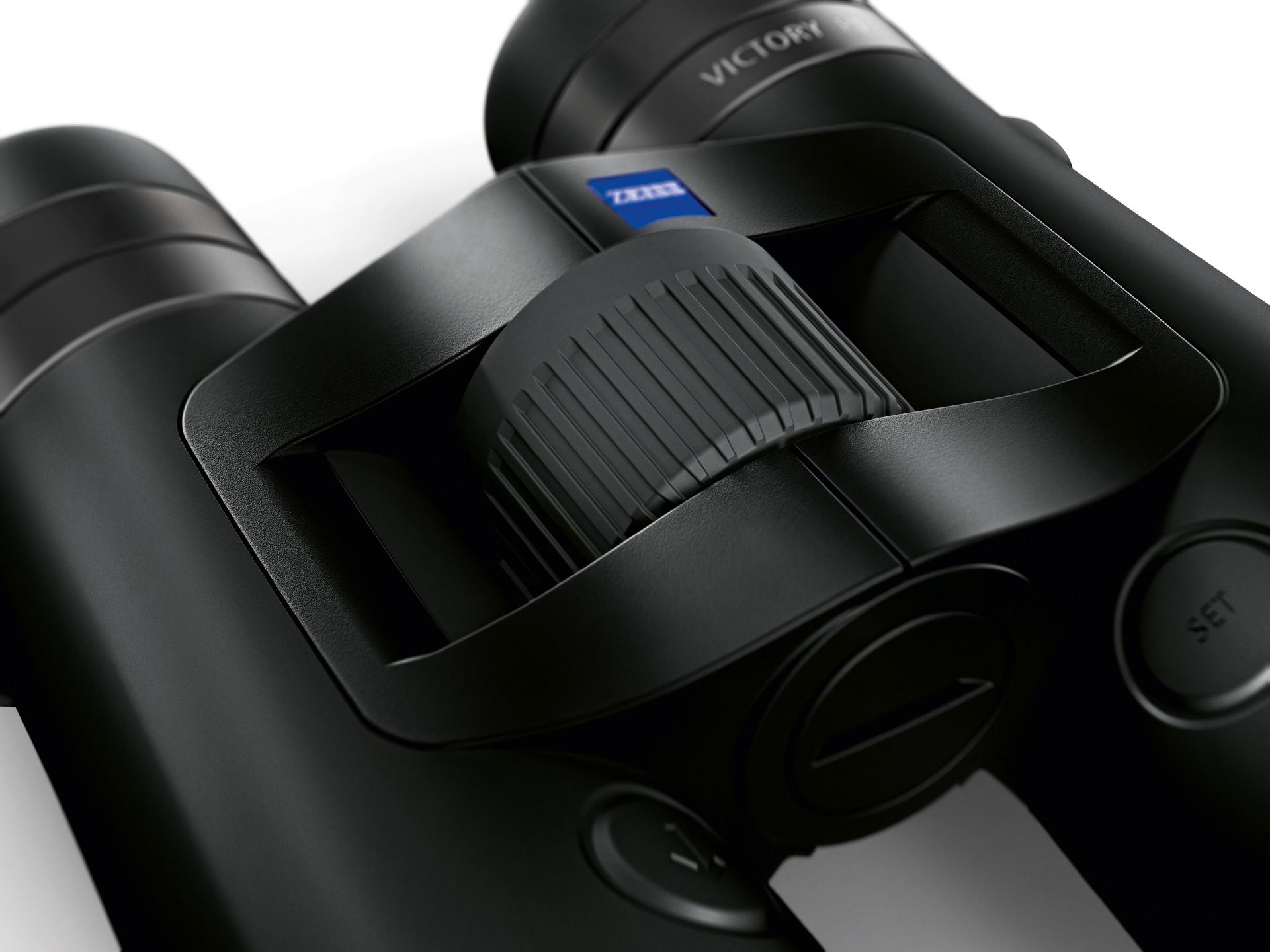 Close-up view of the central focusing wheel and ergonomic design of a pair of ZEISS Victory binoculars.