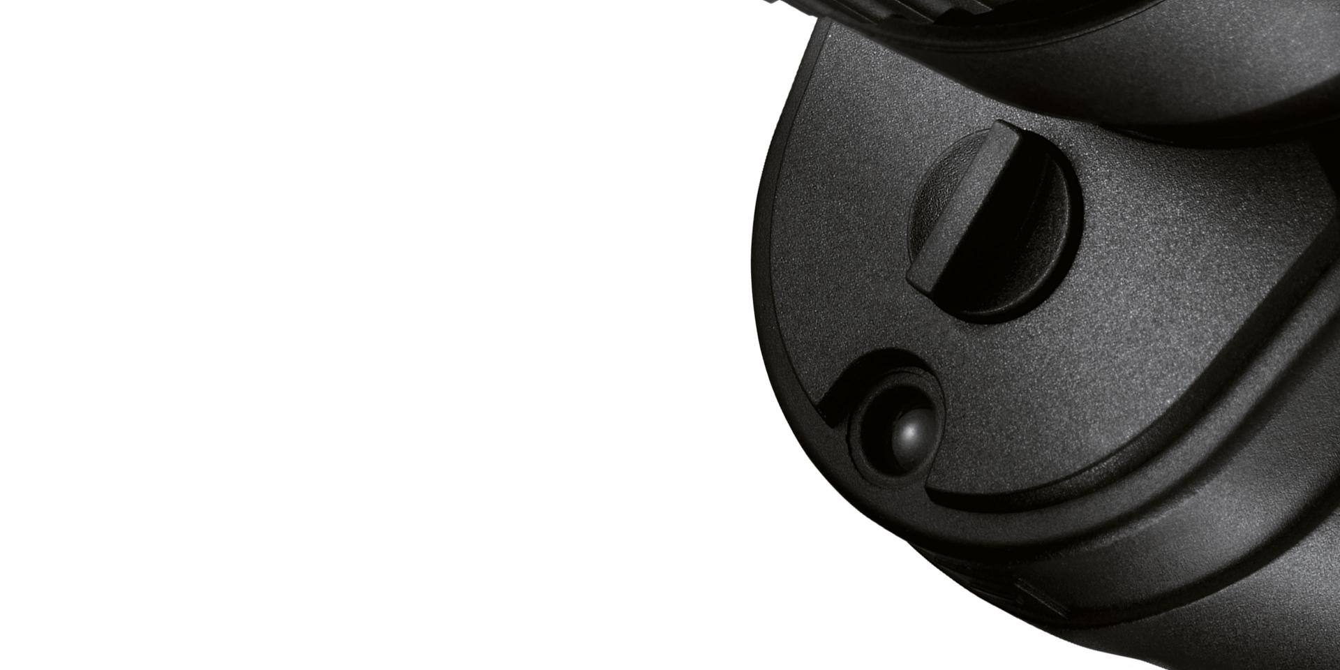 Close-up view of a black circular component of a ZEISS optical device with a textured surface and a small protruding element.
