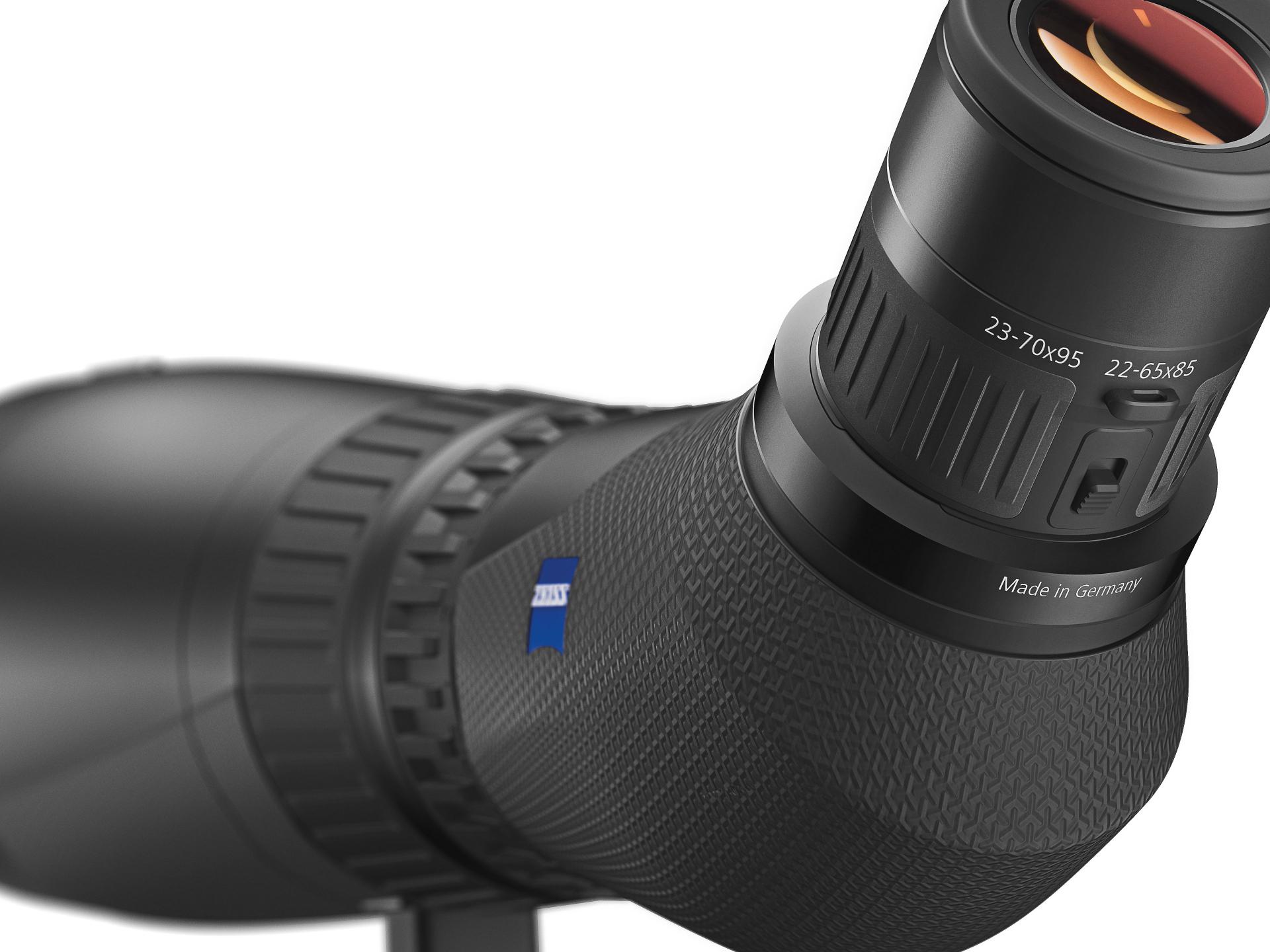Close-up view of a ZEISS spotting scope featuring a textured grip, zoom eyepiece marked 23–70×95, and the ZEISS logo on the body.