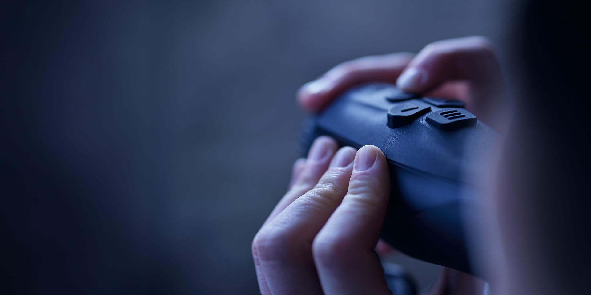 Close-up of a person's hands operating a black ZEISS device with prominent control buttons.
