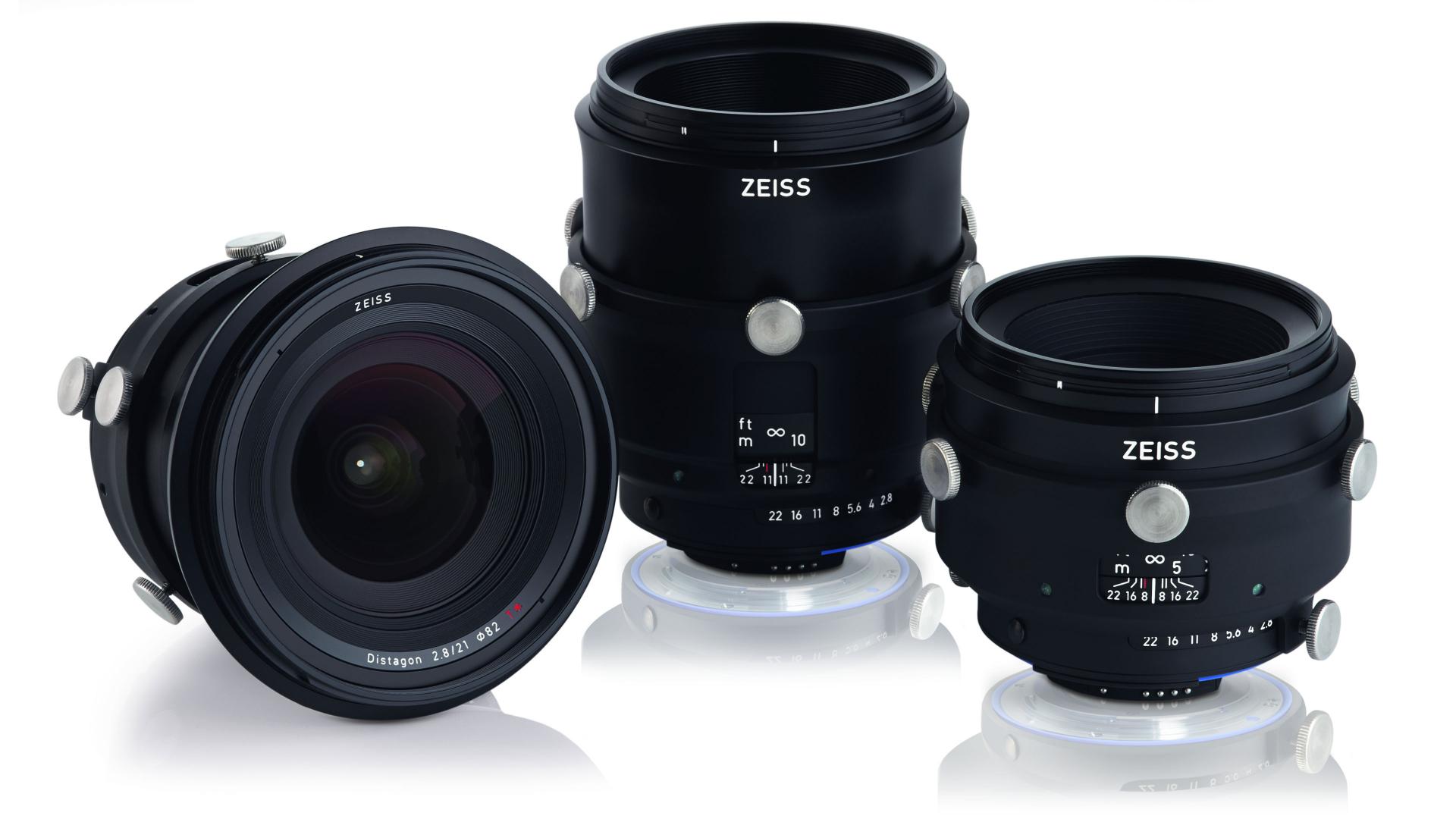 Three professional ZEISS camera lenses with focus and aperture markings displayed on a white background.