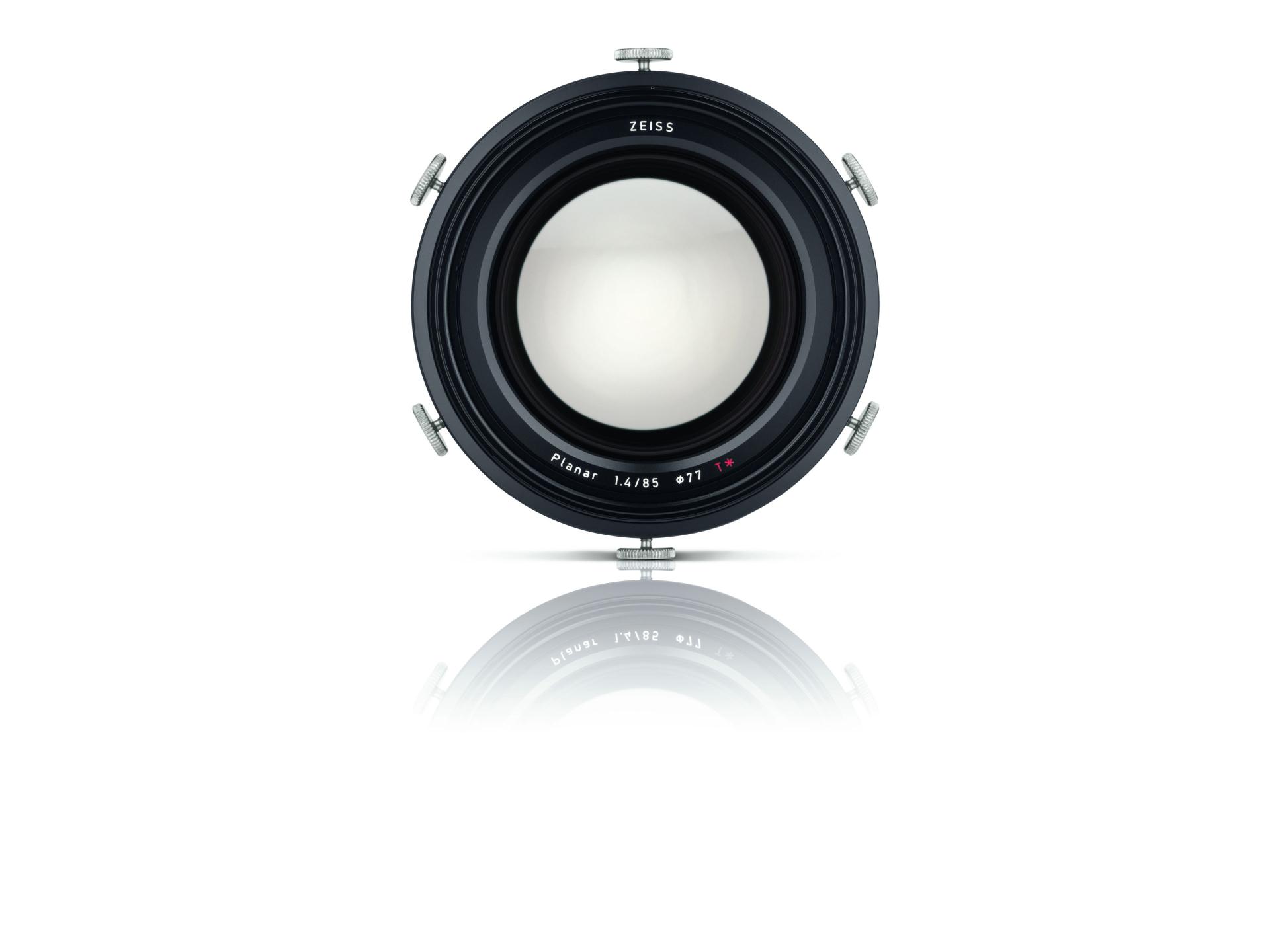 Front view of a ZEISS camera lens with metallic mounting brackets and reflective surface underneath.