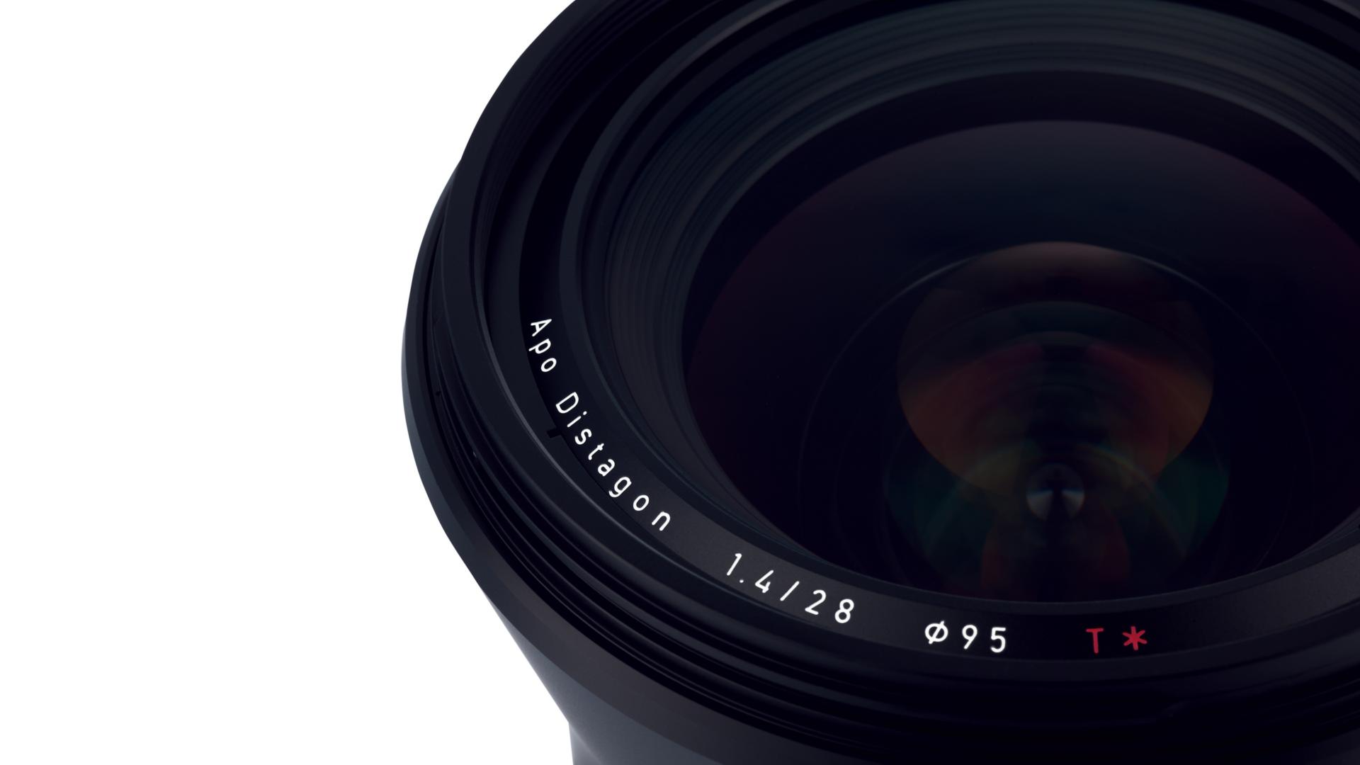 Close-up view of a ZEISS Apo Distagon 1.4/28 camera lens with visible front element and engraved specifications.