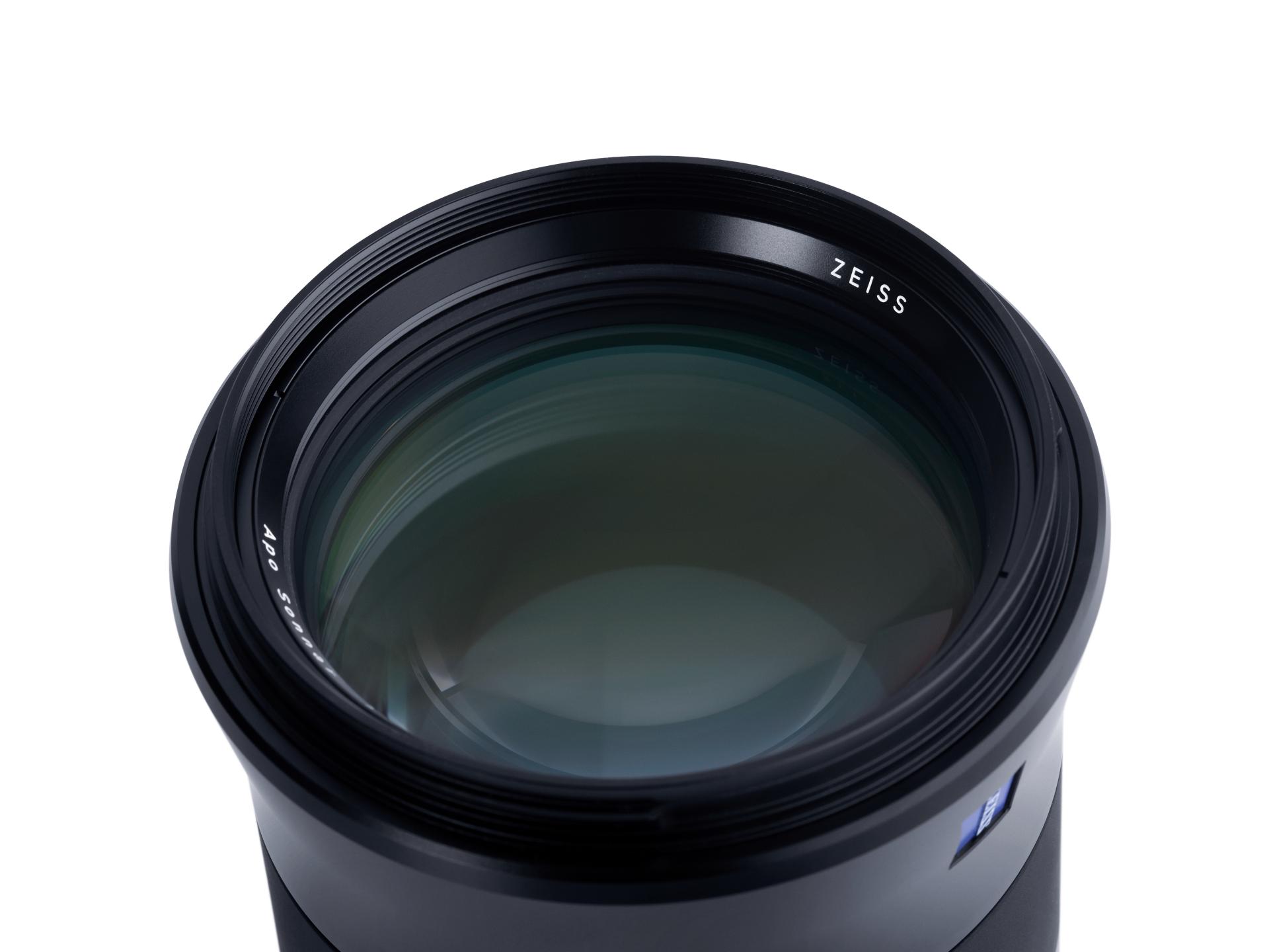 Close-up view of a ZEISS camera lens with a reflective glass surface and visible branding.