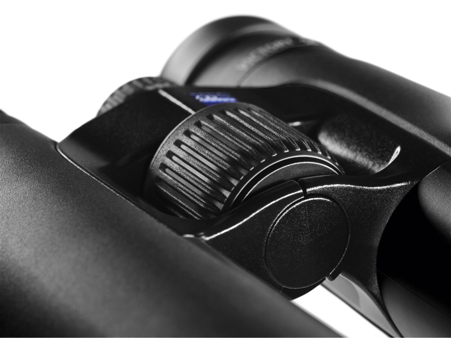 Close-up of the central focusing wheel on a pair of black ZEISS binoculars, showing detailed texture and precision engineering.