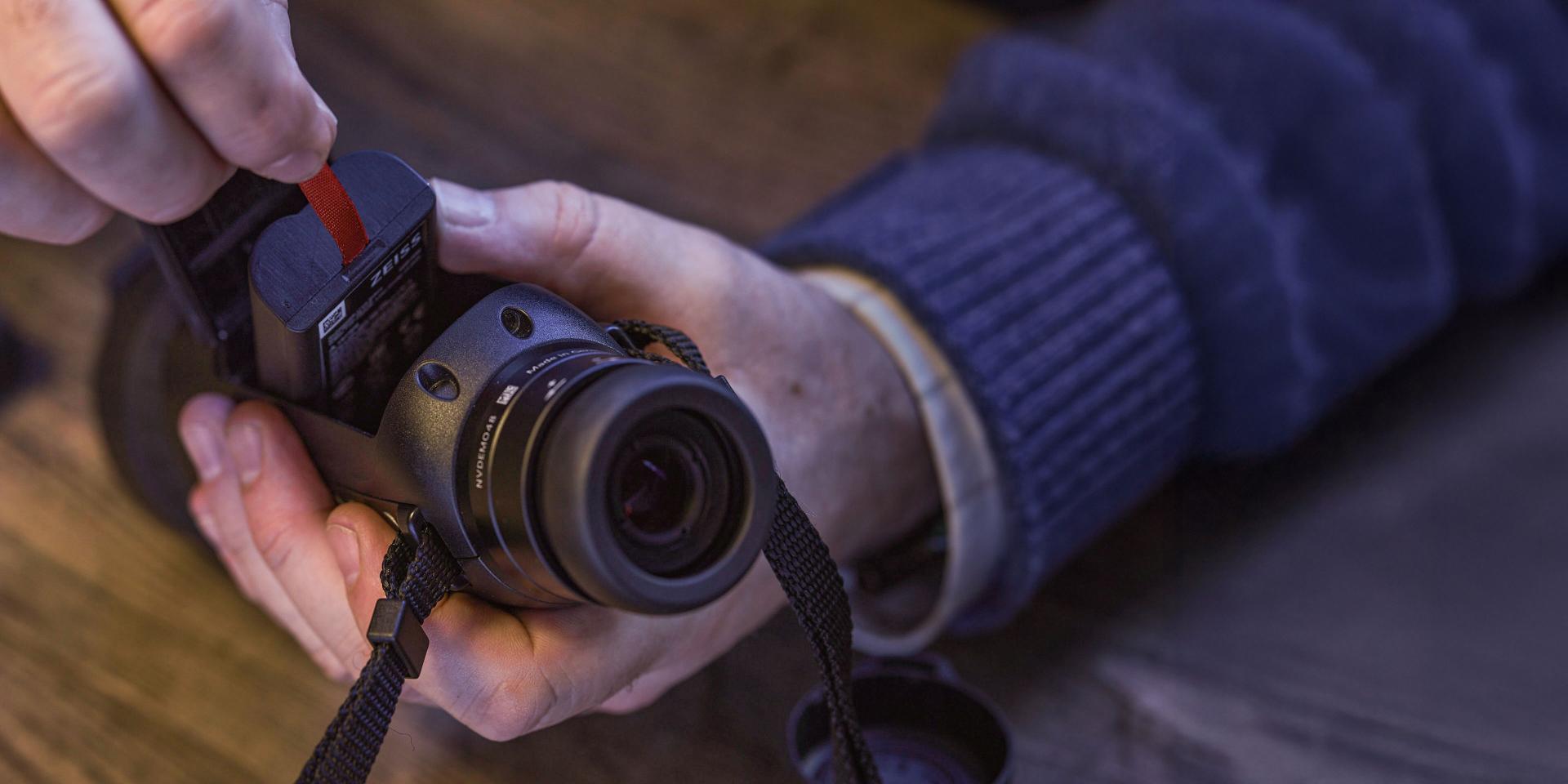 A person inserts a memory card into the slot of a compact ZEISS DTI 6.