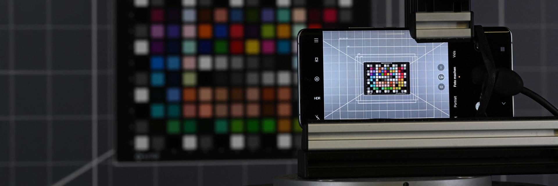 A ZEISS mobile imaging setup captures a color calibration chart with a smartphone mounted on a precision testing rig.
