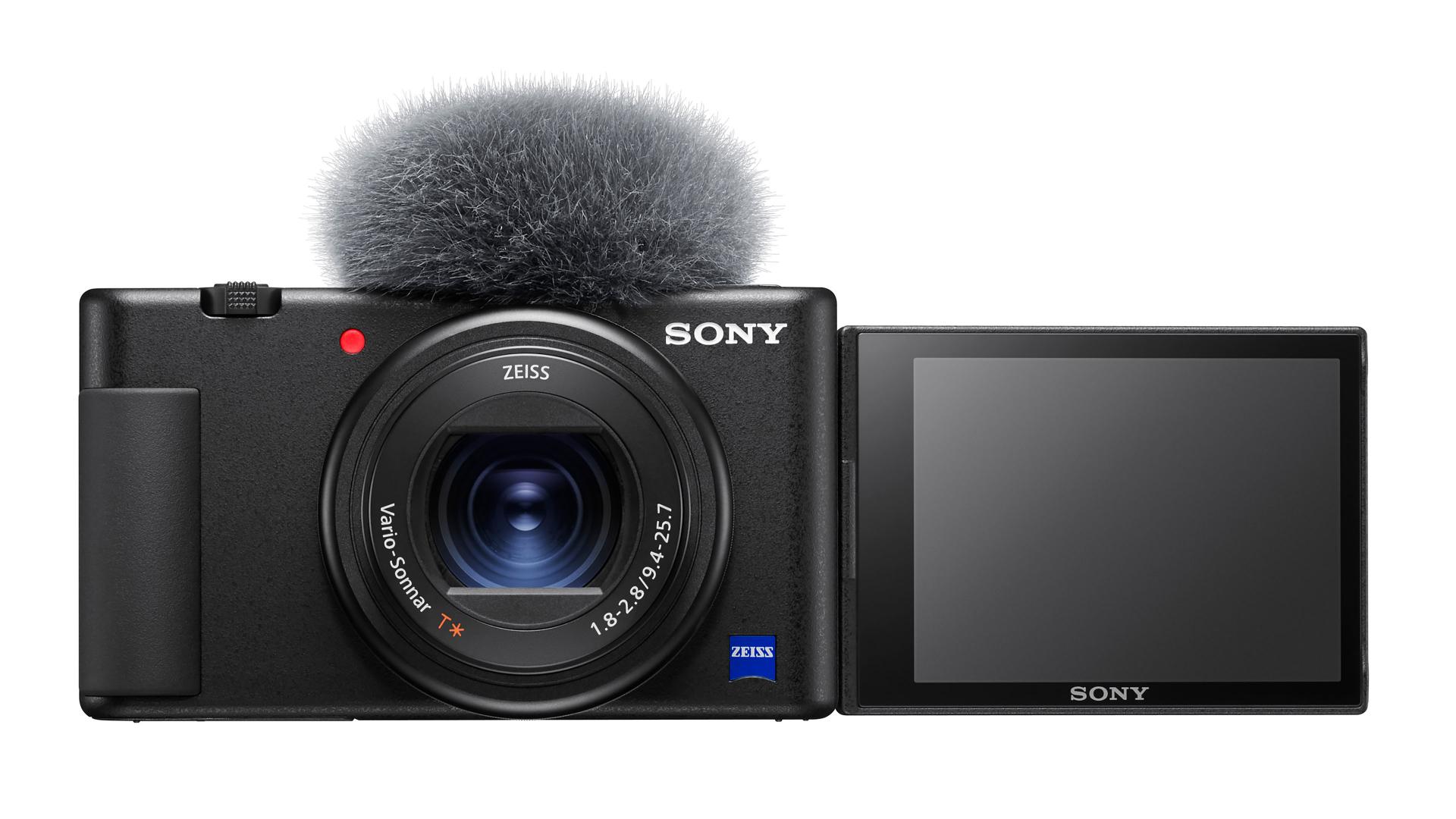 Compact digital camera with ZEISS Vario-Sonnar T* lens, built-in microphone with windscreen, and a flip-out LCD screen.