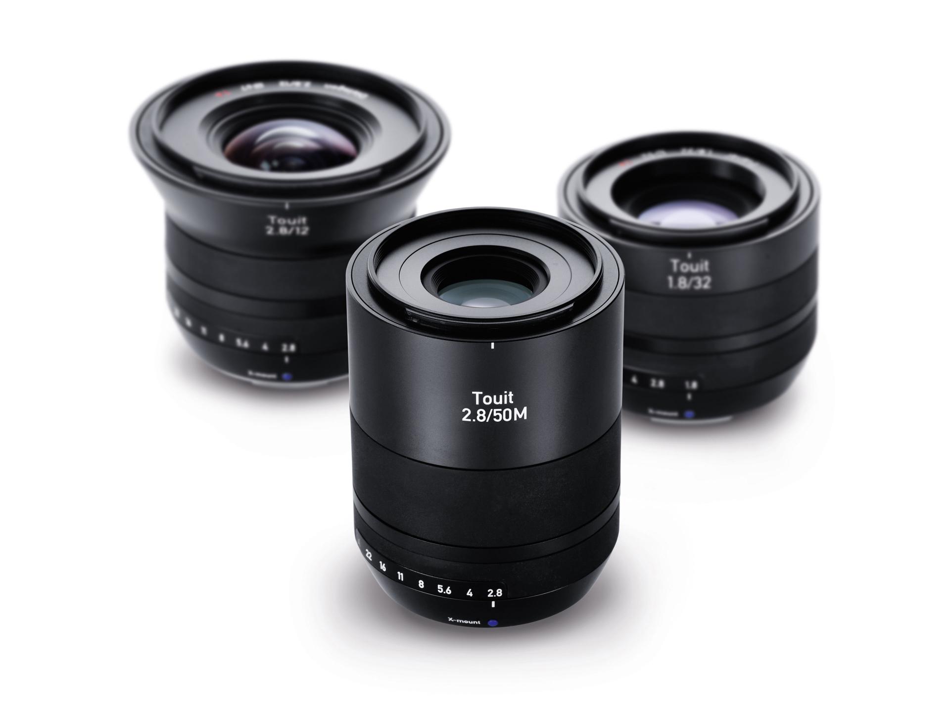 Three ZEISS Touit 2.8/12 camera lenses with lens hoods are displayed side by side on a white background.