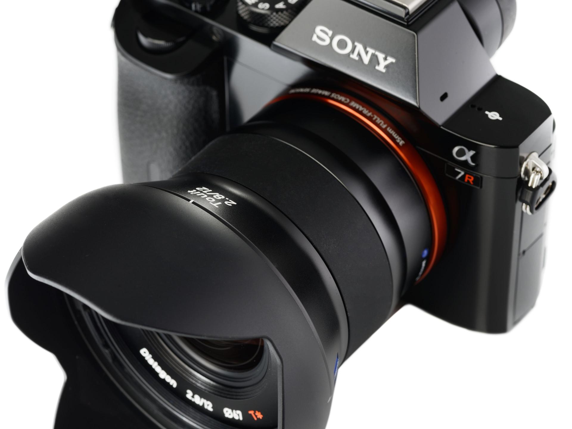 Two ZEISS Touit 1.8/32 camera lenses are shown standing upright against a white background.
