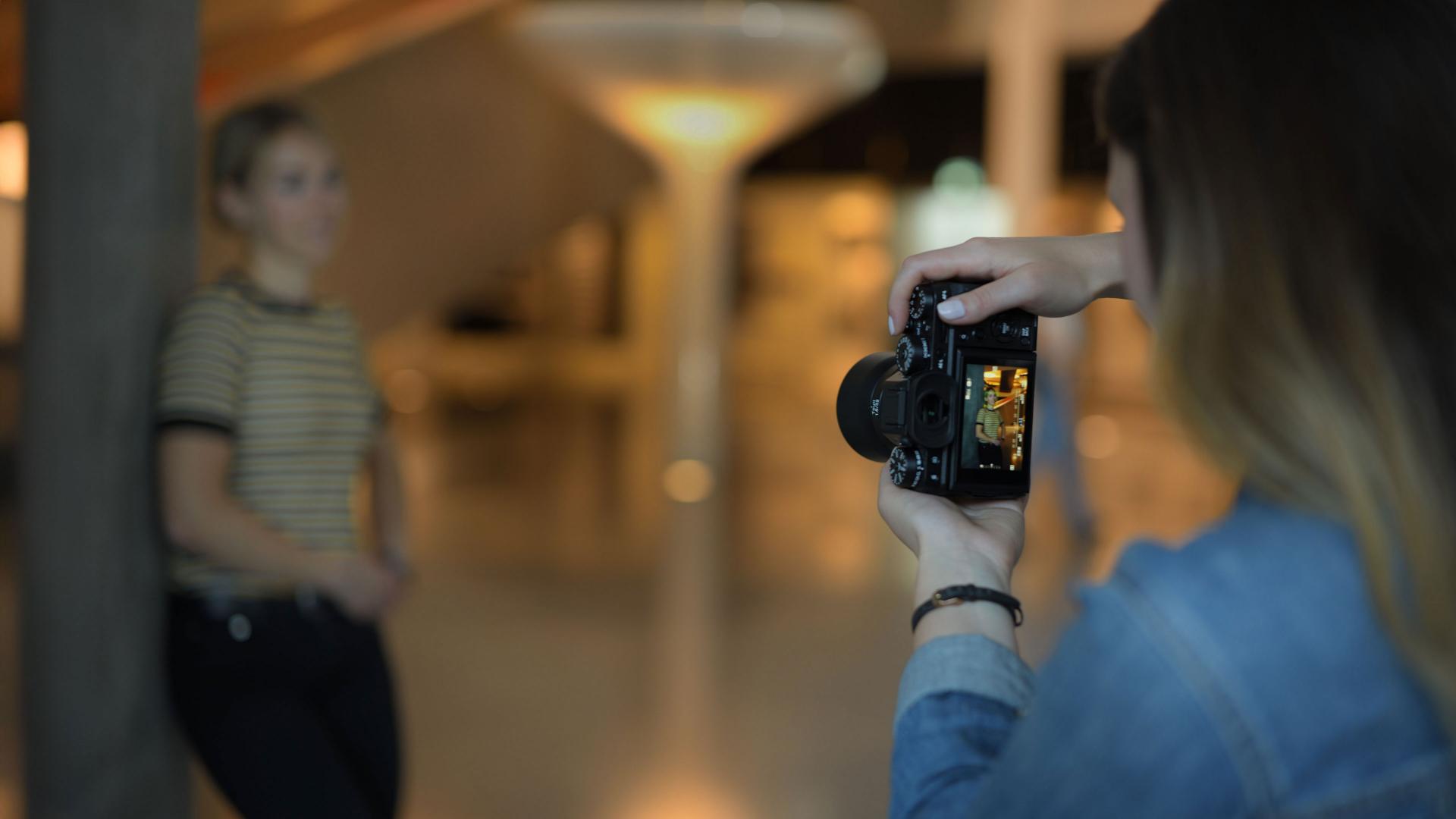 A photographer uses a camera with a ZEISS lens to capture a candid moment, showcasing the clarity and versatility of ZEISS optics in dynamic environments.