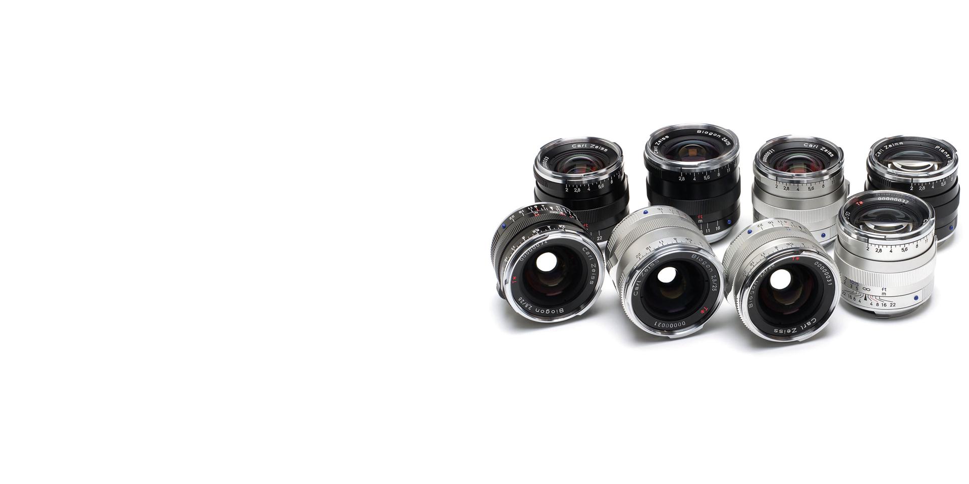 A selection of ZEISS camera lenses arranged in two rows on a white background.