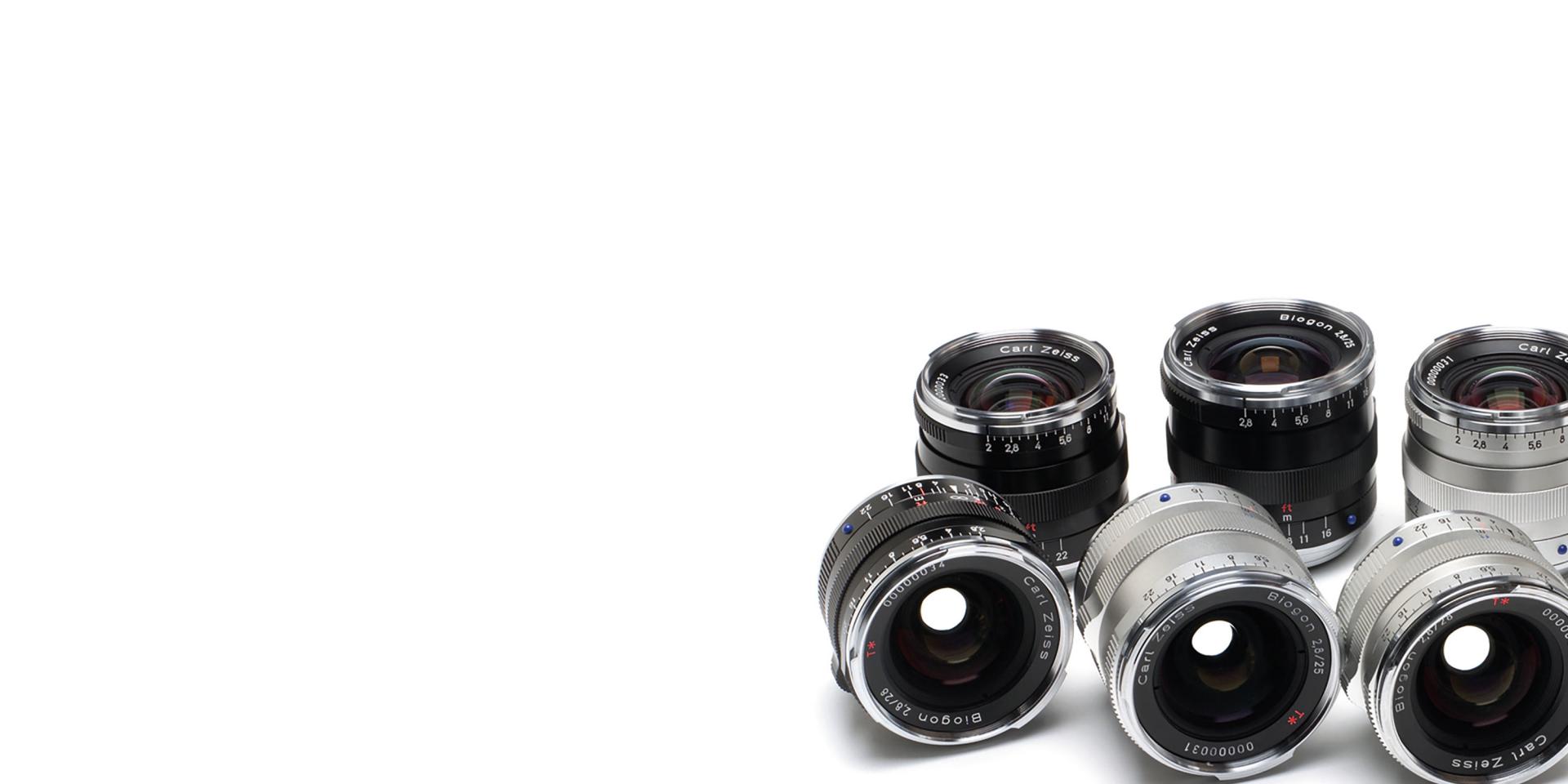 A selection of ZEISS camera lenses arranged in two rows on a white background.
