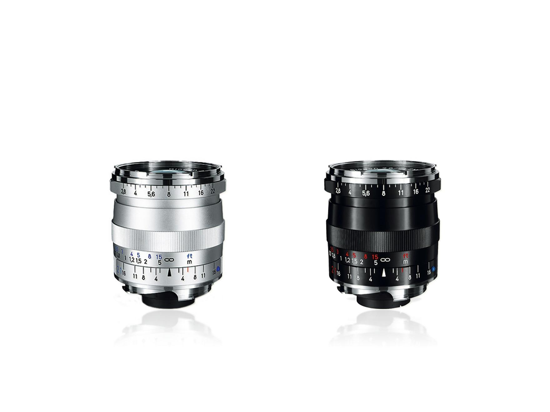 Two ZEISS camera lenses with manual focus and aperture markings in white, red, and blue on a silver and black metal barrel.
