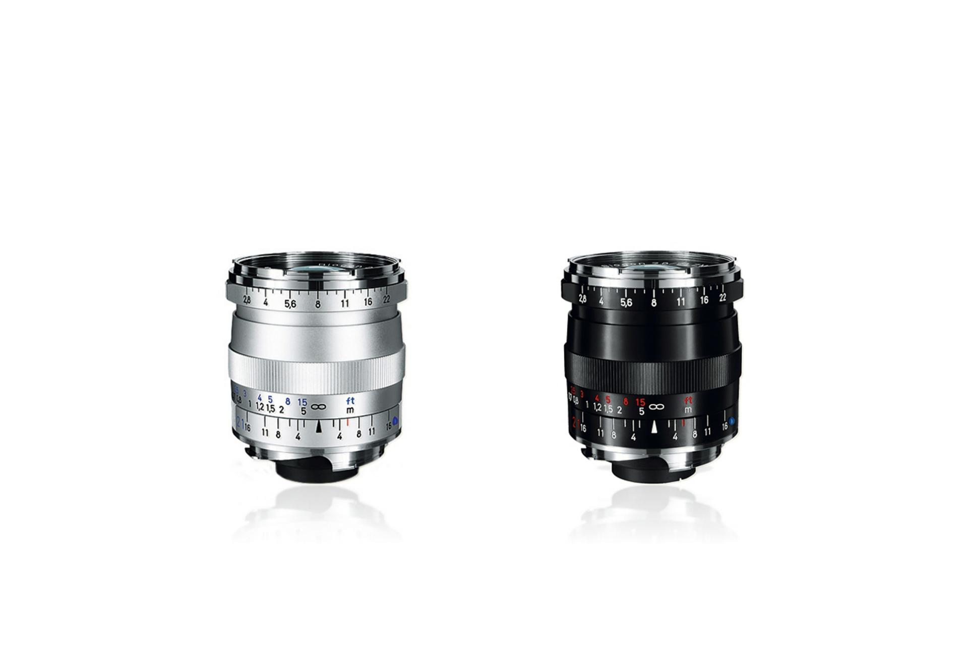 Two ZEISS camera lenses with manual focus and aperture markings in white, red, and blue on a silver and black metal barrel.