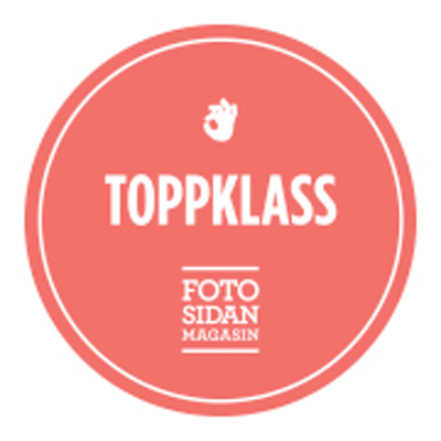 Red circular badge with the text "TOPPKLASS" and "FOTOSIDAN MAGASIN" along with a hand gesture symbol above the text.