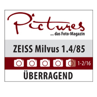 Award graphic from "Pictures – das Foto-Magazin" showing the ZEISS Milvus 1.4/85 lens rated as "ÜBERRAGEND" (outstanding) with five out of five cameras.