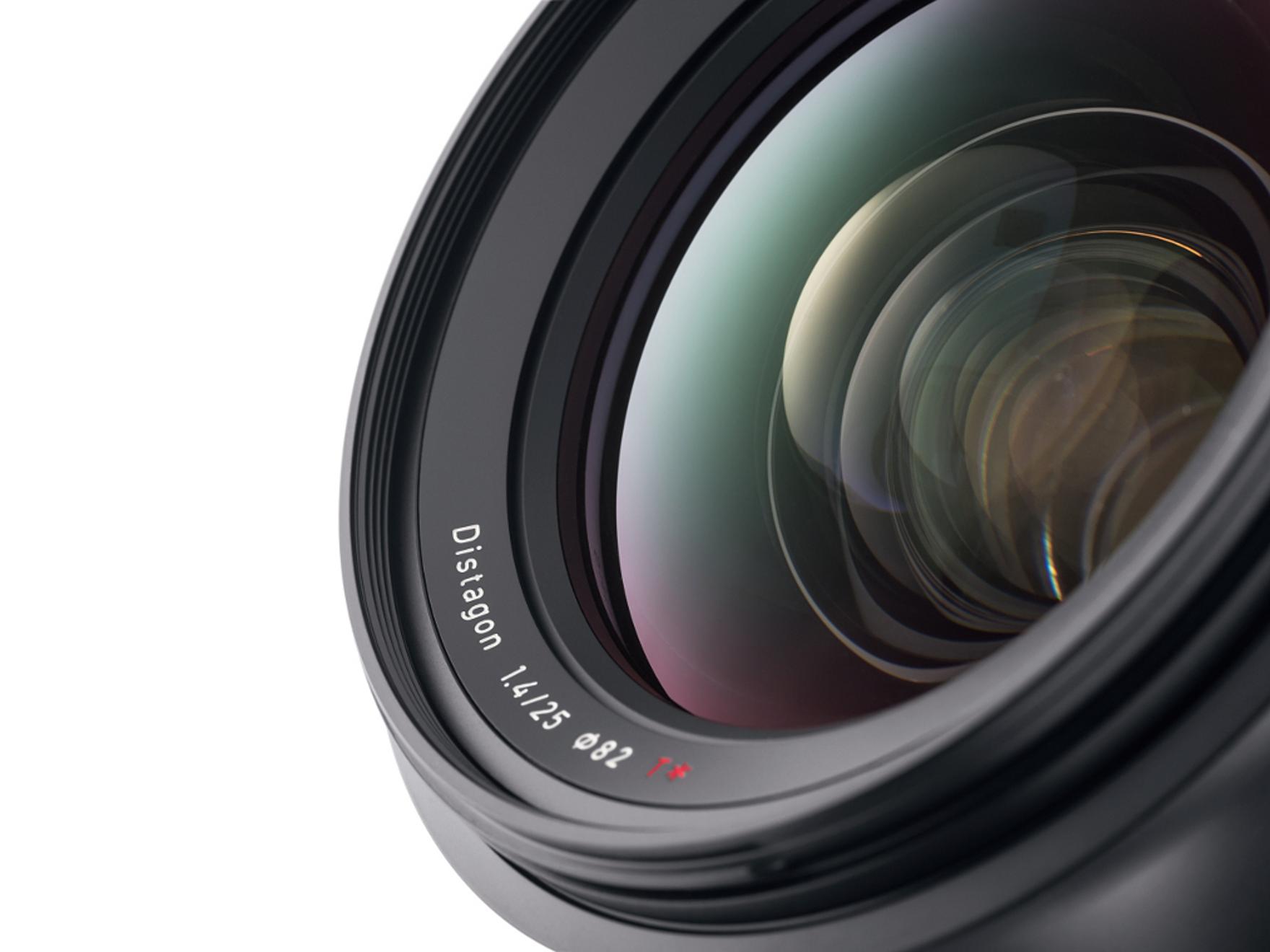 Close-up view of a ZEISS Distagon 1.4/25 camera lens showing detailed glass elements and lens markings.