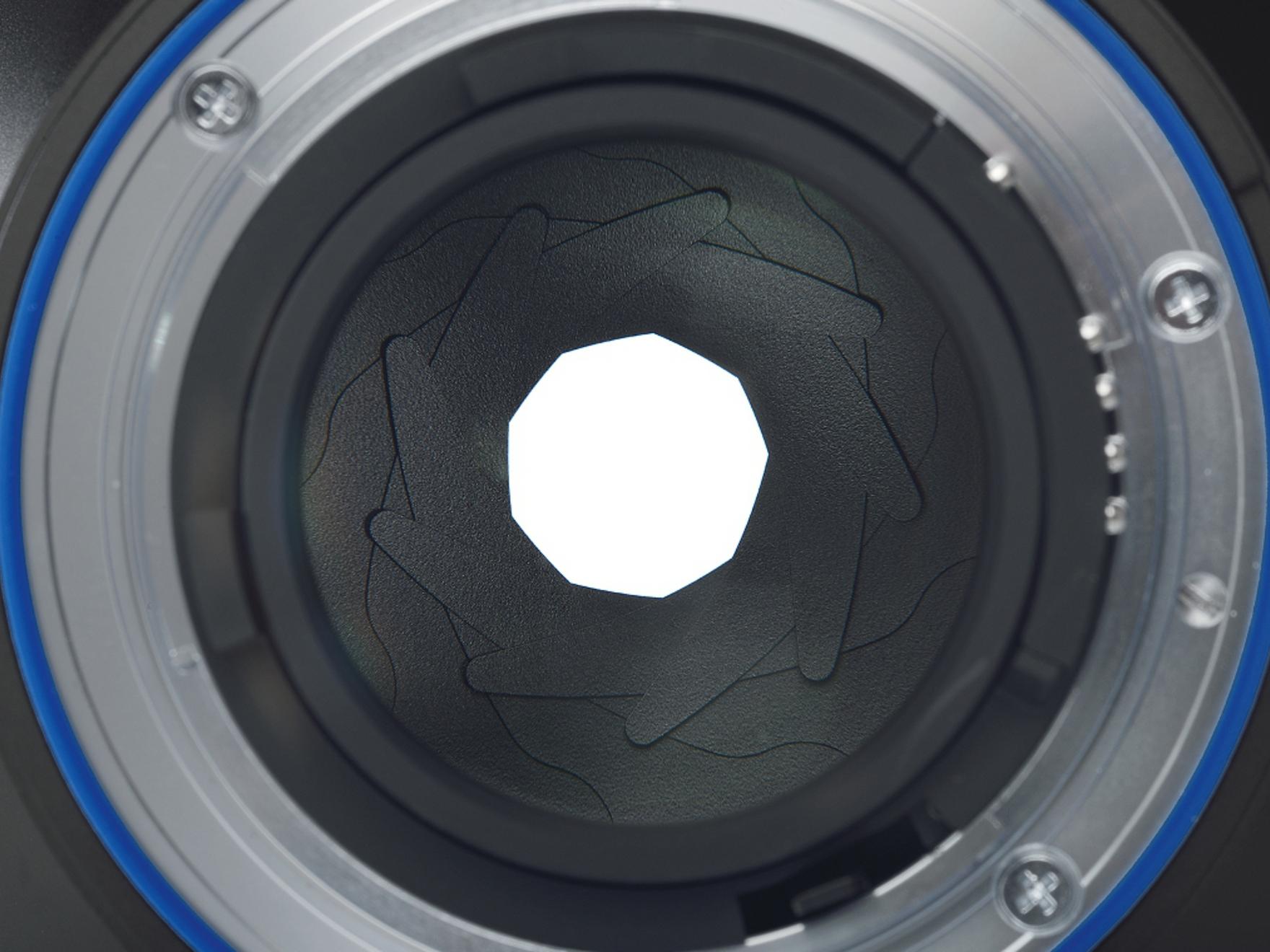 Close-up view of the aperture blades inside a ZEISS camera lens, showing the detailed mechanical structure.
