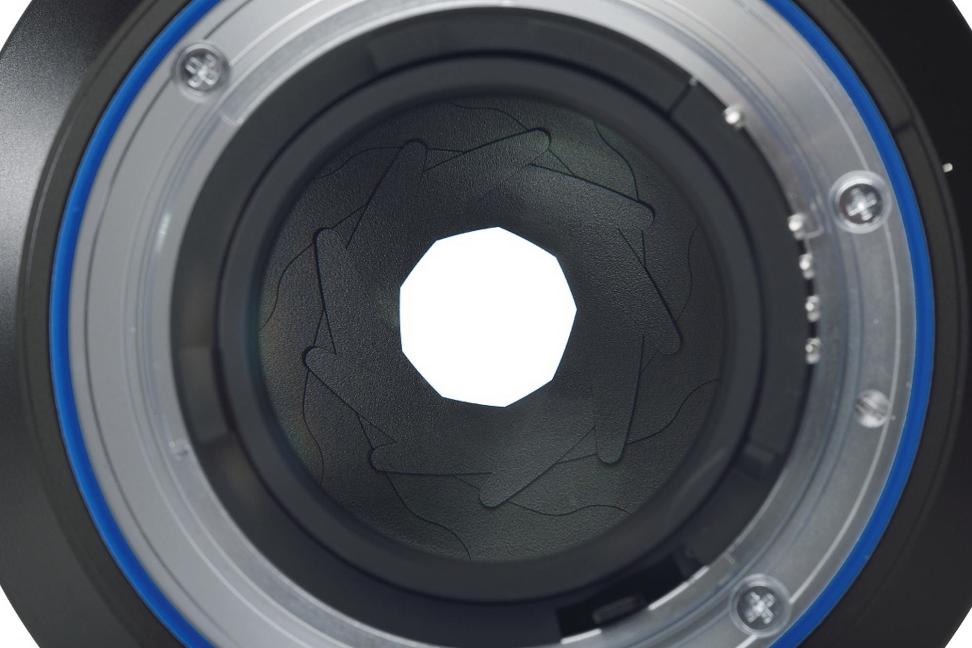 Close-up view of the aperture blades inside a ZEISS camera lens, showing the detailed mechanical structure.