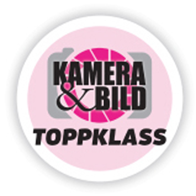 Circular badge with a pink camera icon and the text "KAMERA & BILD TOPPKLASS" in black letters.