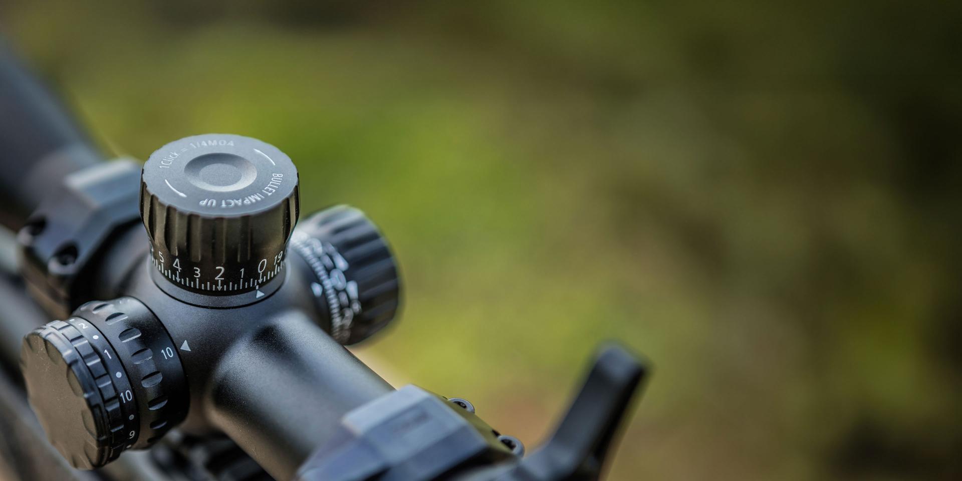 Close-up view of a ZEISS rifle scope with precision adjustment dials and a matte black finish.