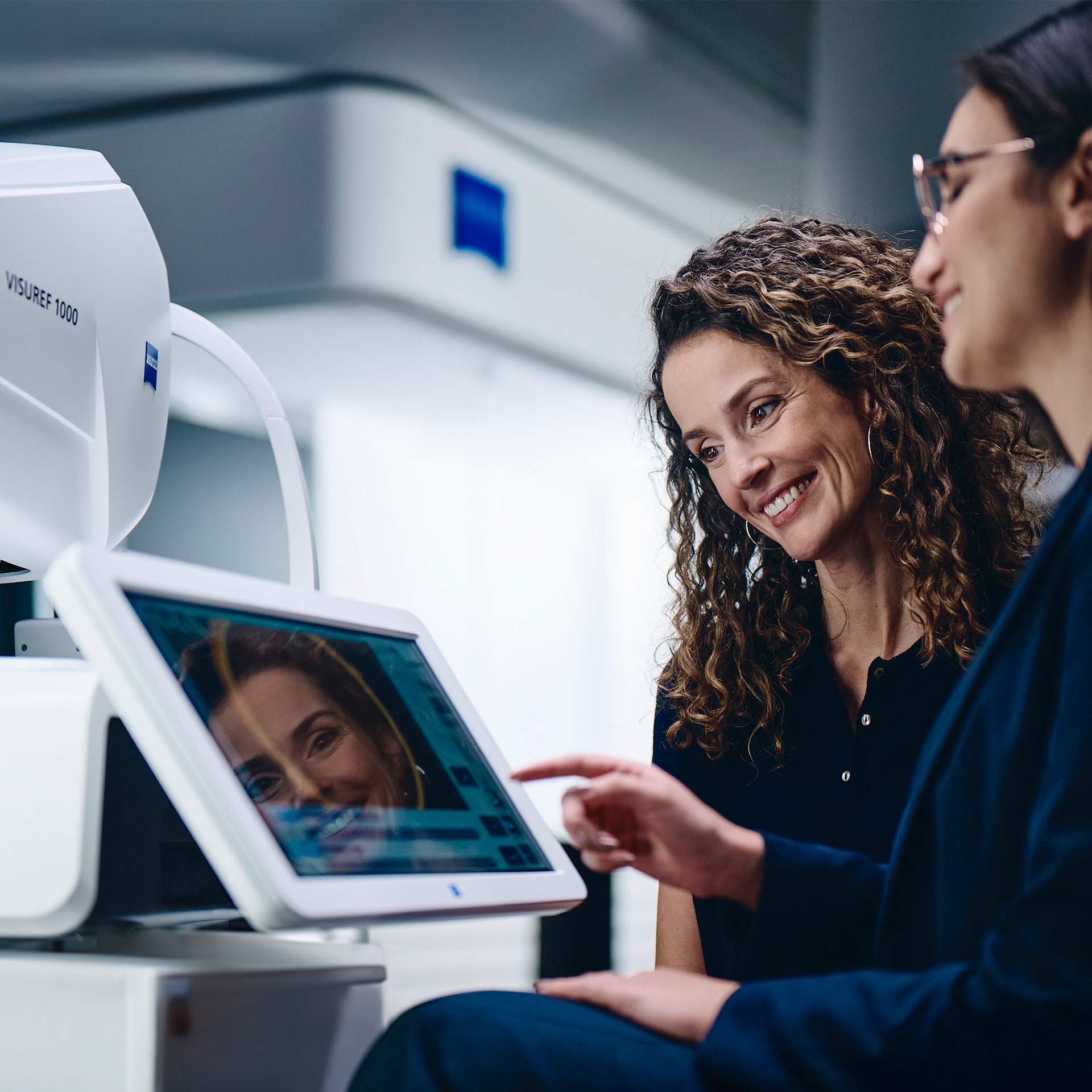 Two women looking at the screen of the ZEISS VISUREF 1000.