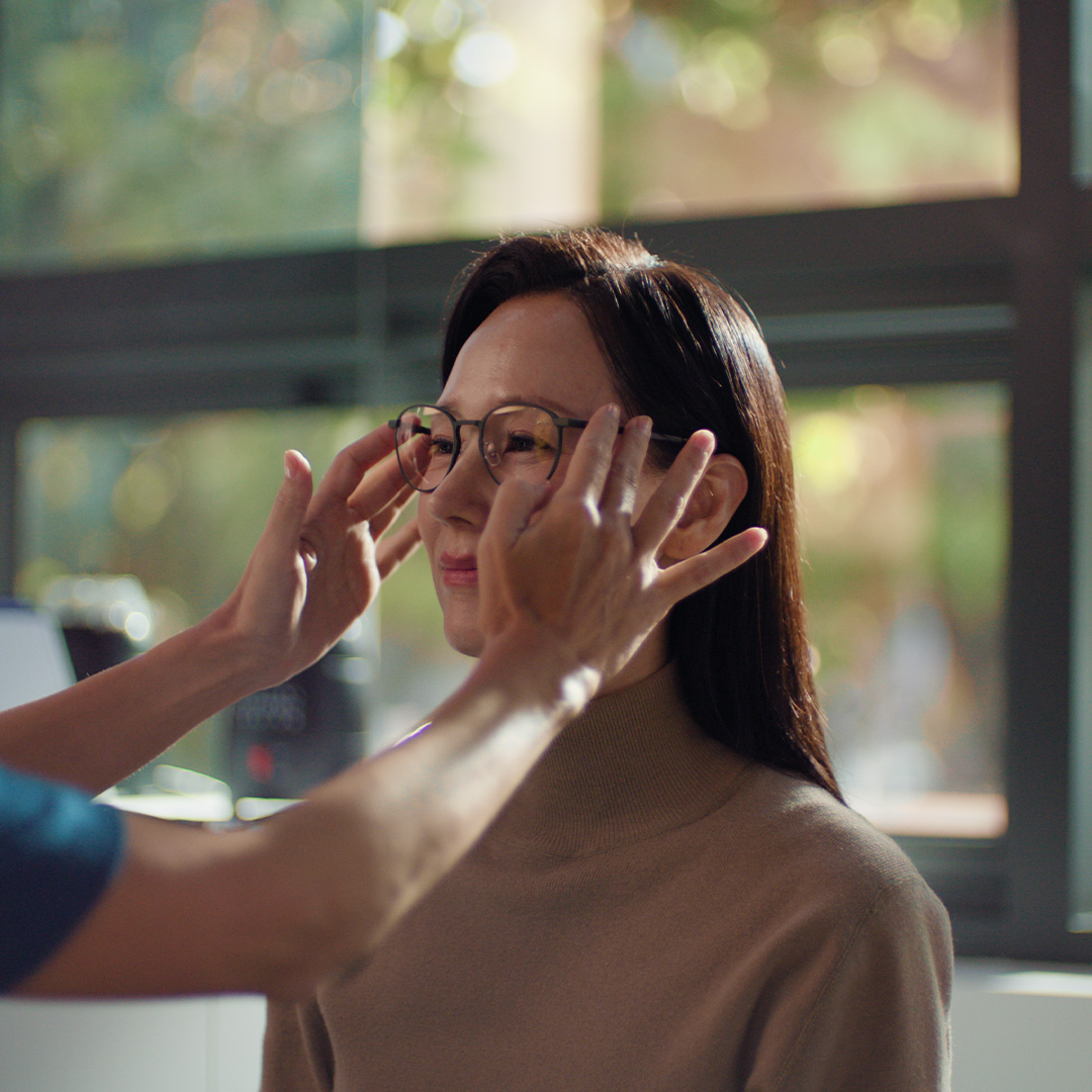 A woman trying on glasses.