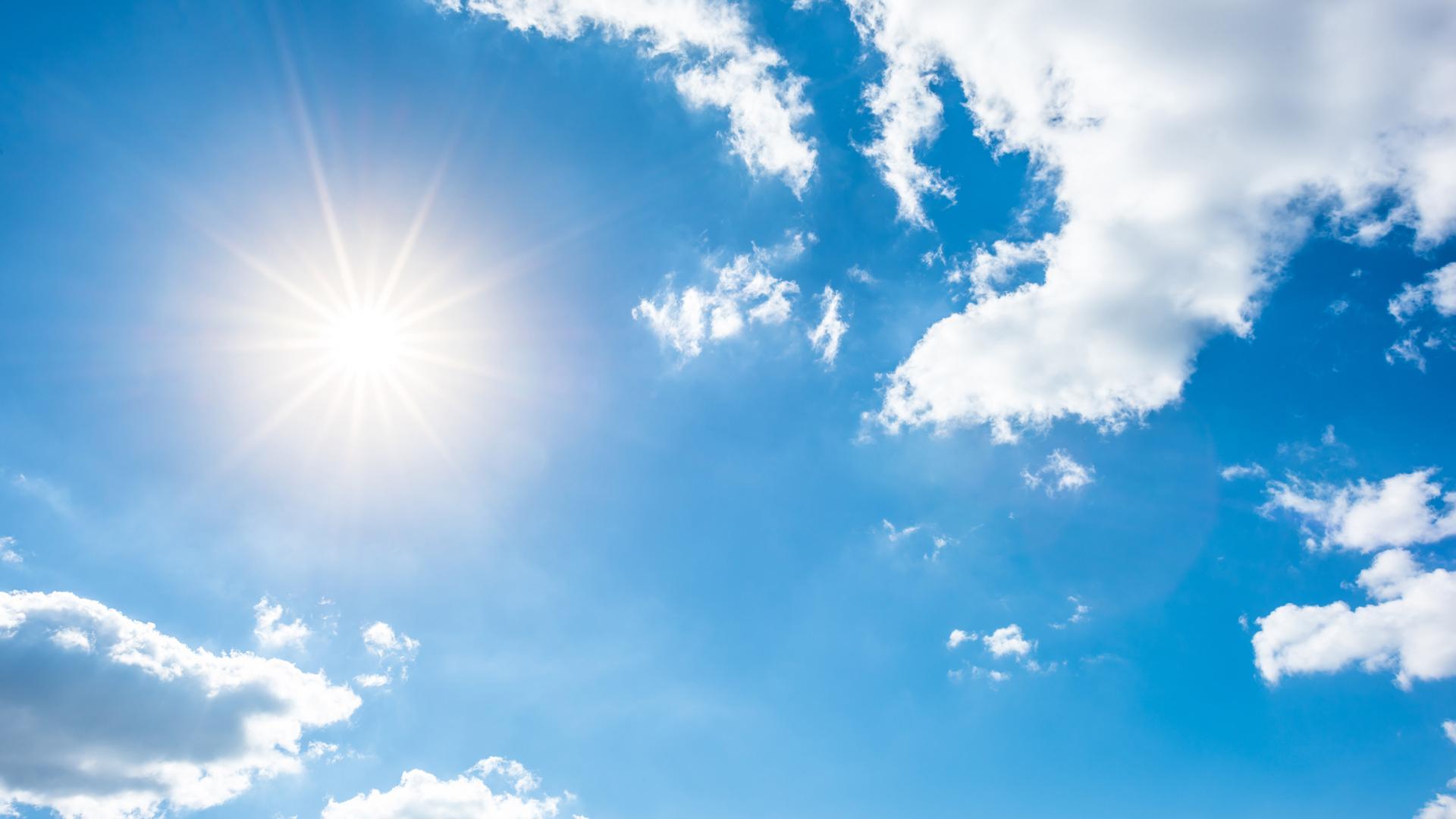 Sunny background, blue sky with white clouds and sun