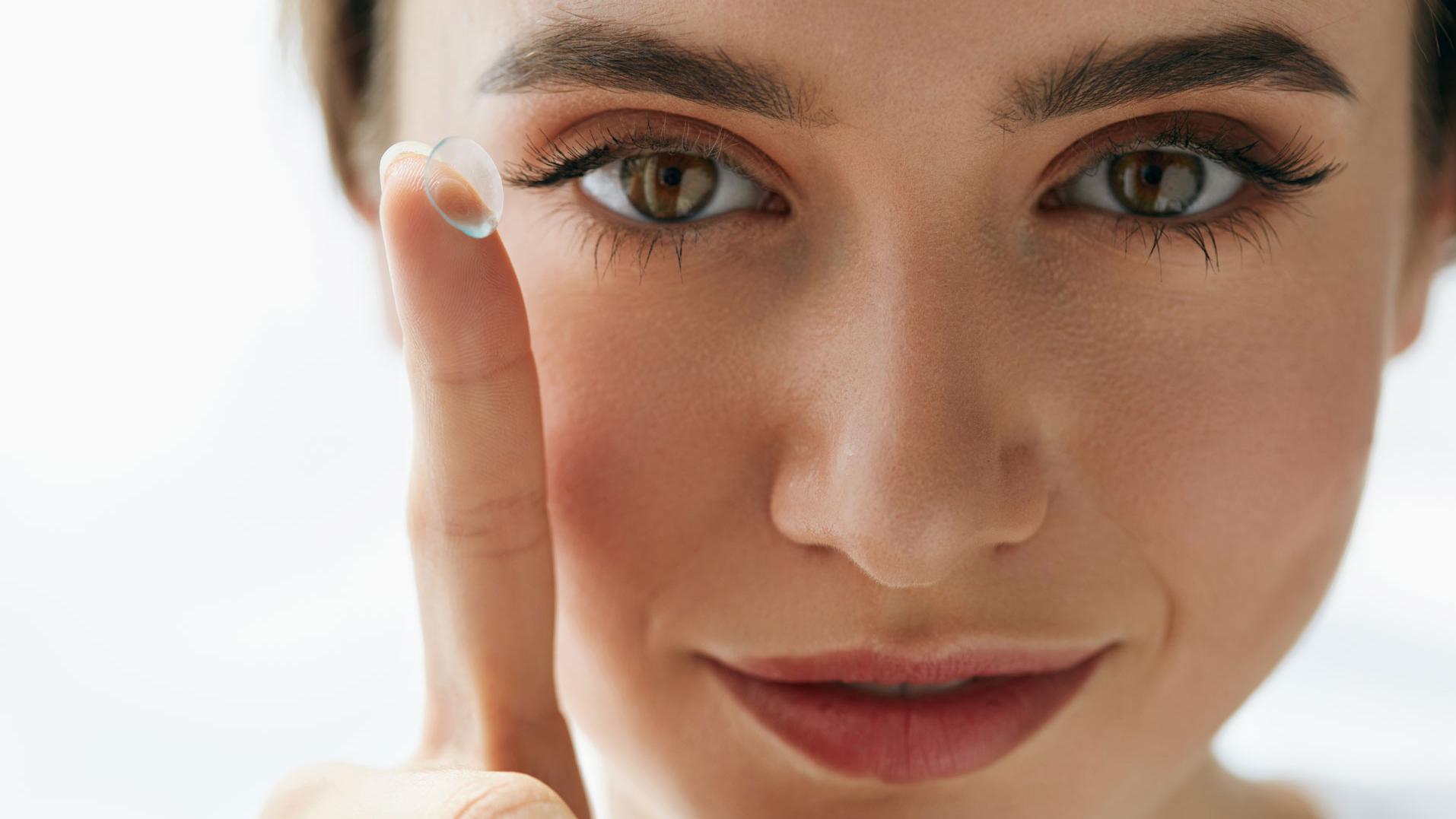 Closeup Of Beautiful Woman Applying Eye Lens In Eye
