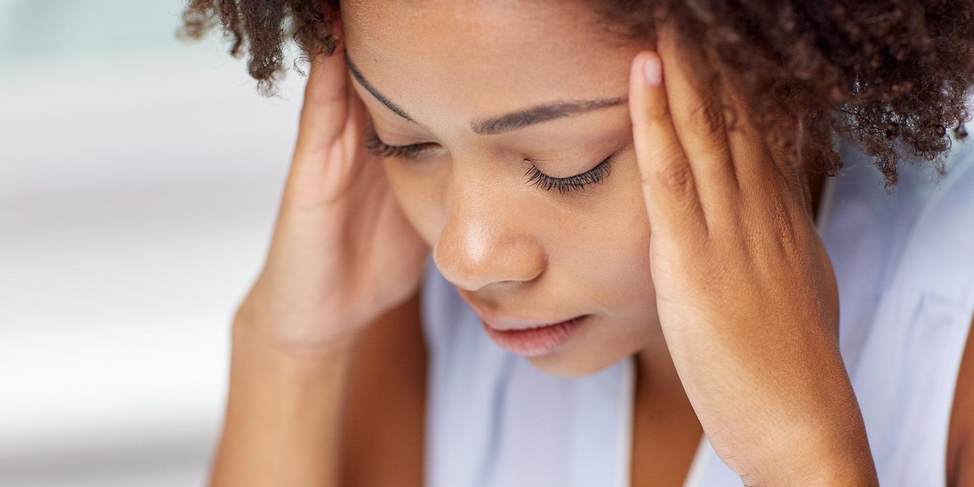 Close up of african young woman touching her head