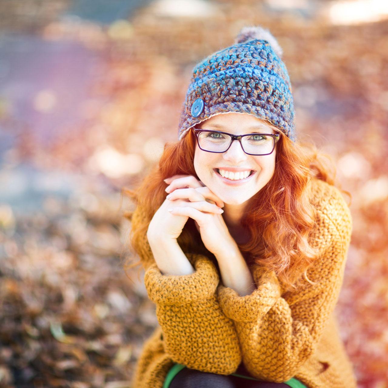 Positive woman with red hair and glasses