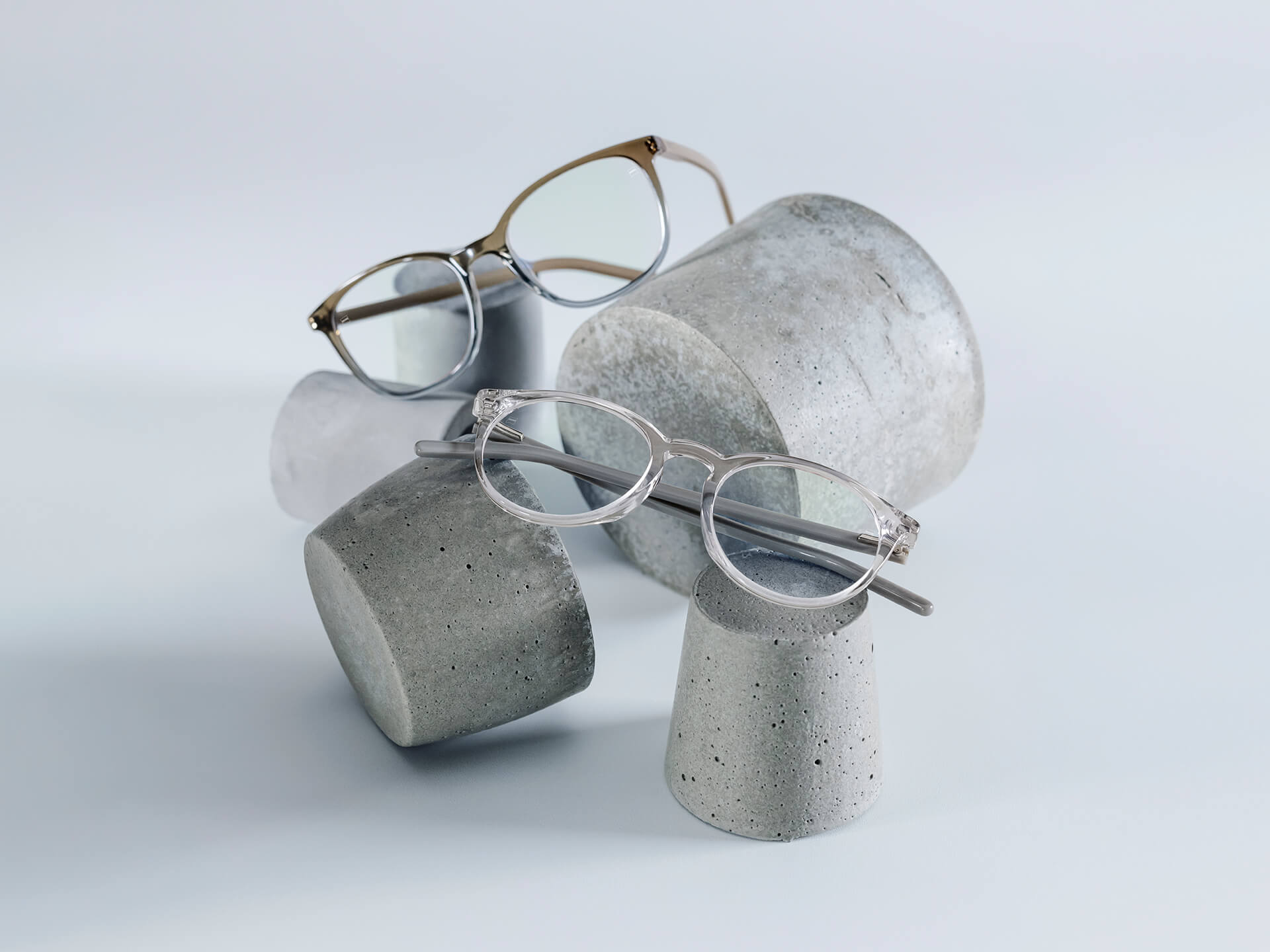 Glasses with ZEISS lenses that have DuraVision® Chrome coatings are placed on stone pedestals of different sizes.